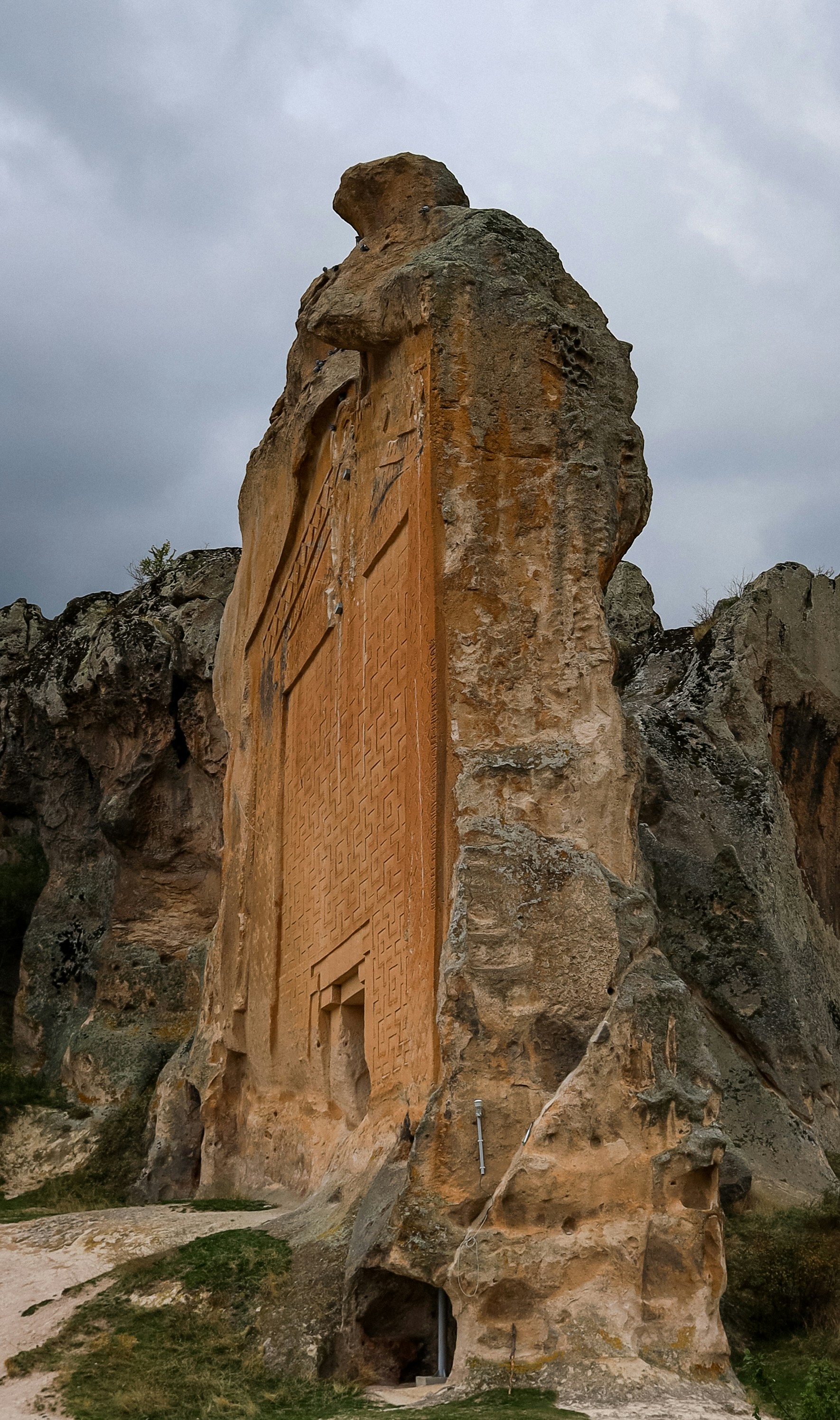 Uralte geschnitzte Felsformationen unter einem wolkenverhangenen Himmel