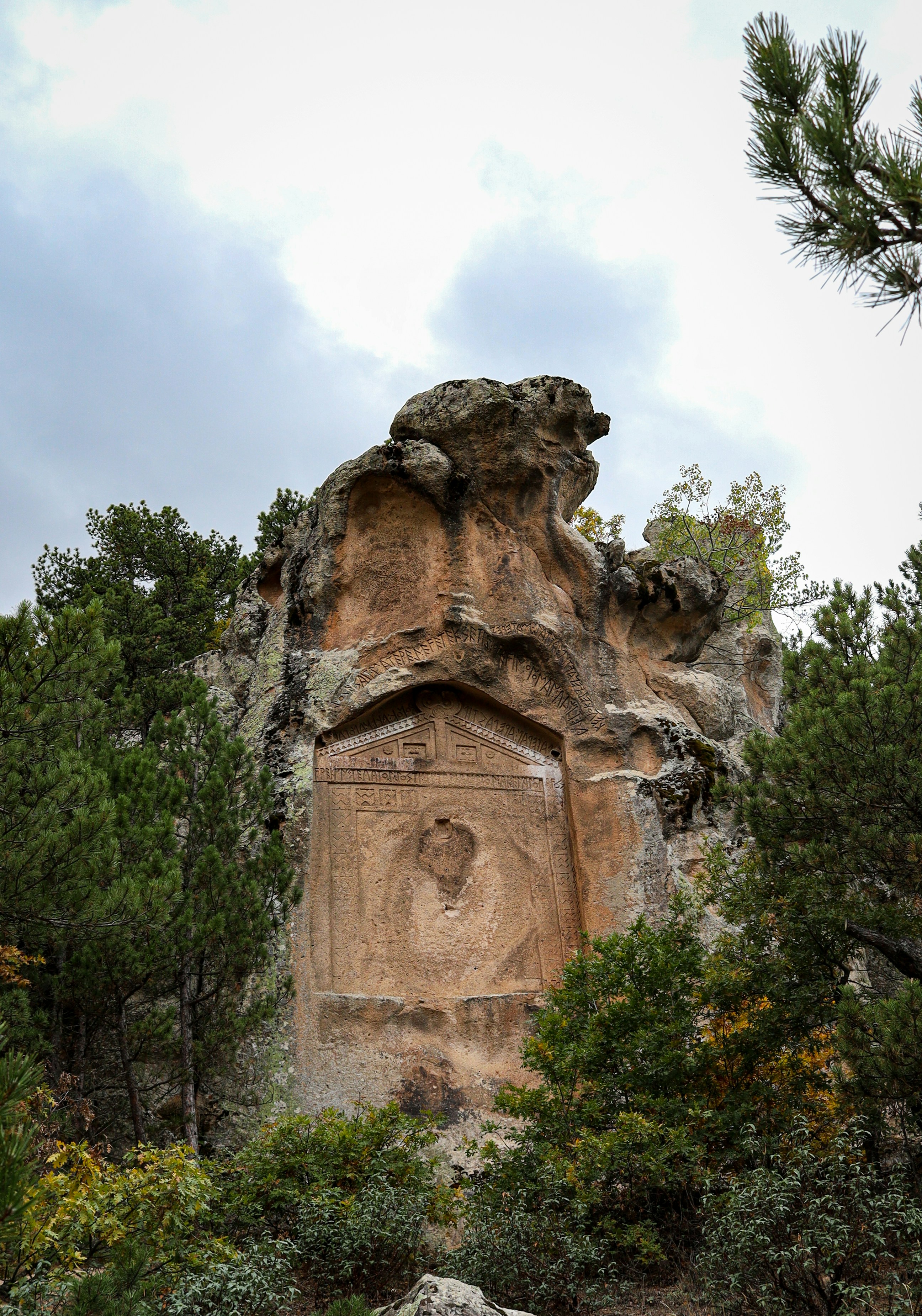 Antikes Felsmonument, umgeben von Bäumen