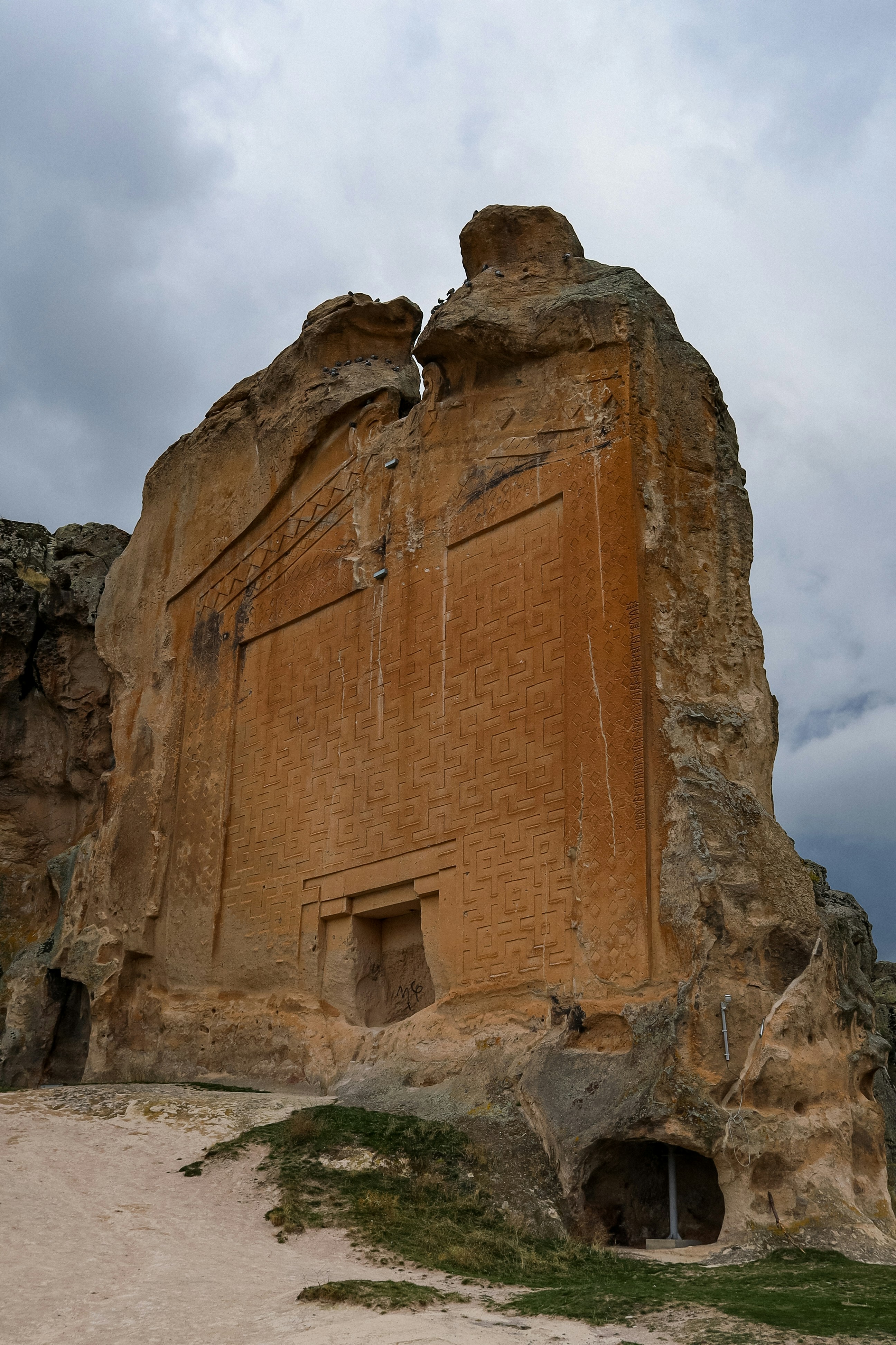 Antikes Felsmonument unter bewölktem Himmel