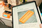 Tablet displaying 3D print progress with printer in background