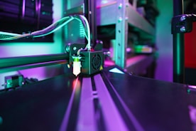3D printer head creating object with purple and green lights