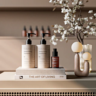 Shampoo, conditioner, and serum bottles on a book.