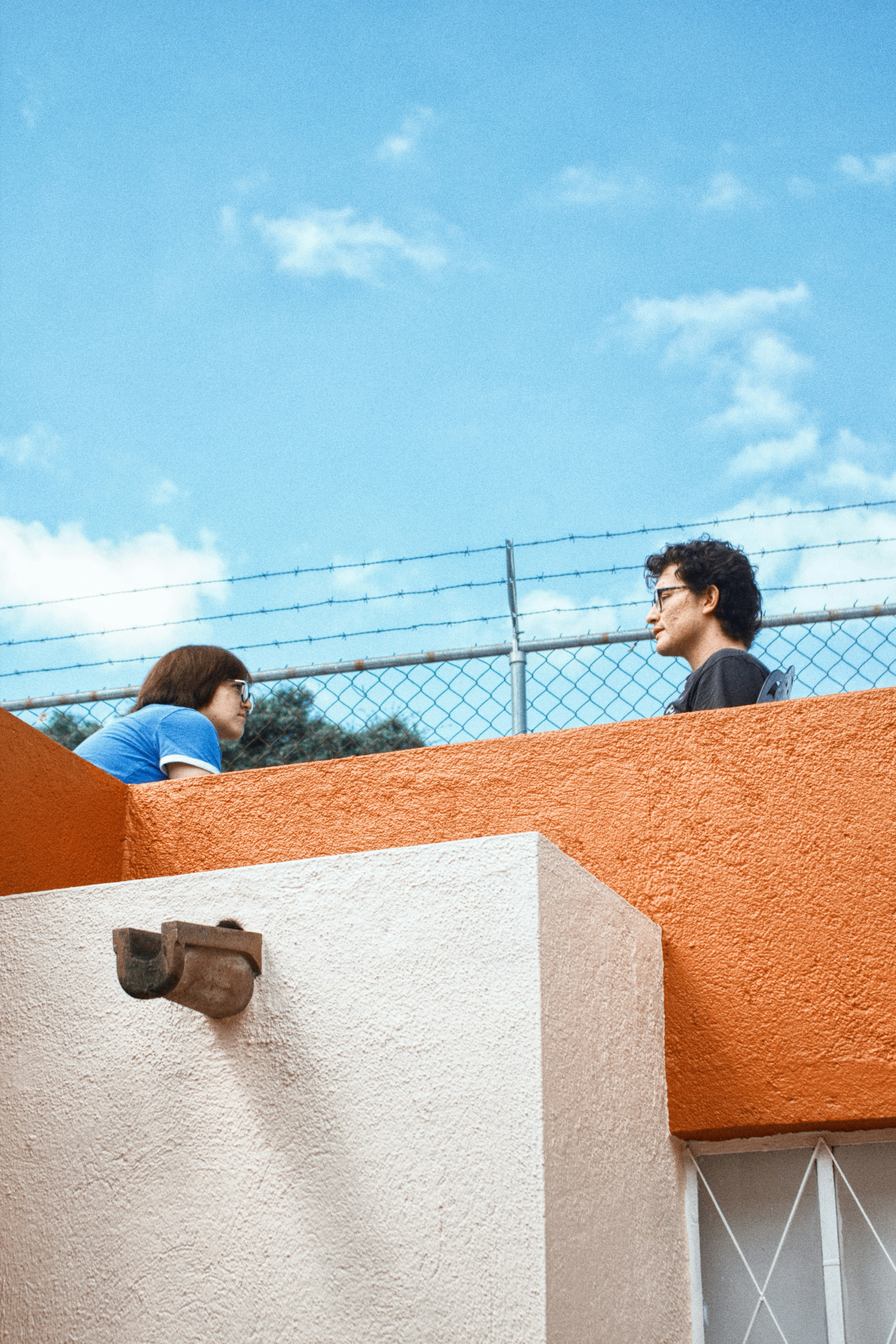 Two people talking on a rooftop