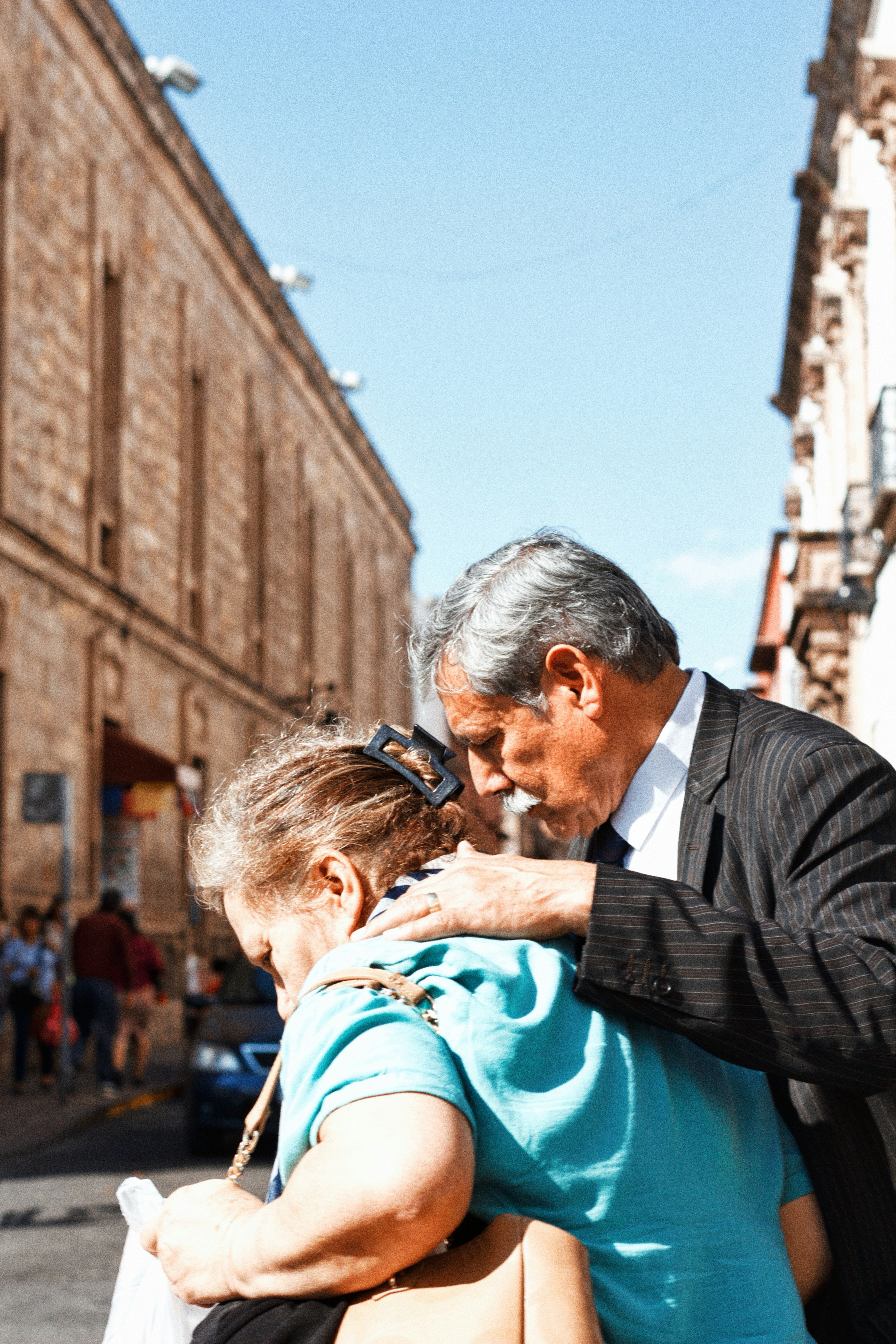 Man comforts woman on city street
