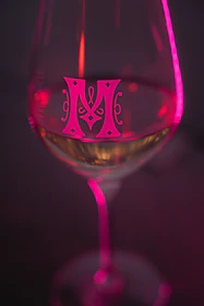 A glass with a decorative "m" and pink lighting