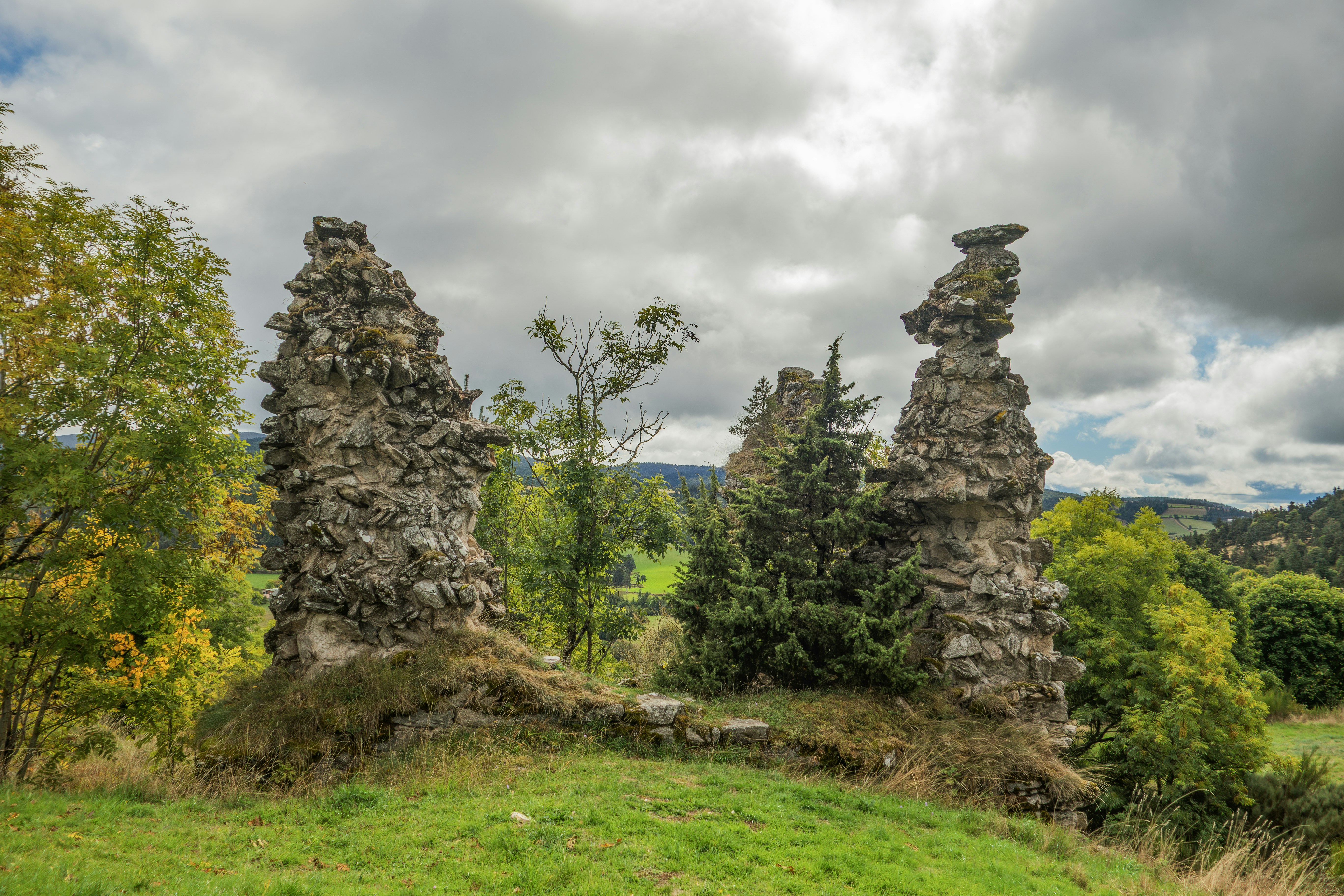 풀이 무성한 언덕에 있는 고대 성의 돌 유적.