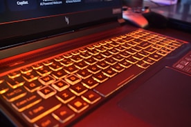 Close-up of a laptop keyboard with orange backlighting.