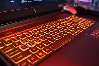 Close-up of a laptop keyboard with orange backlighting.