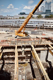 Construction site with crane and trains in background