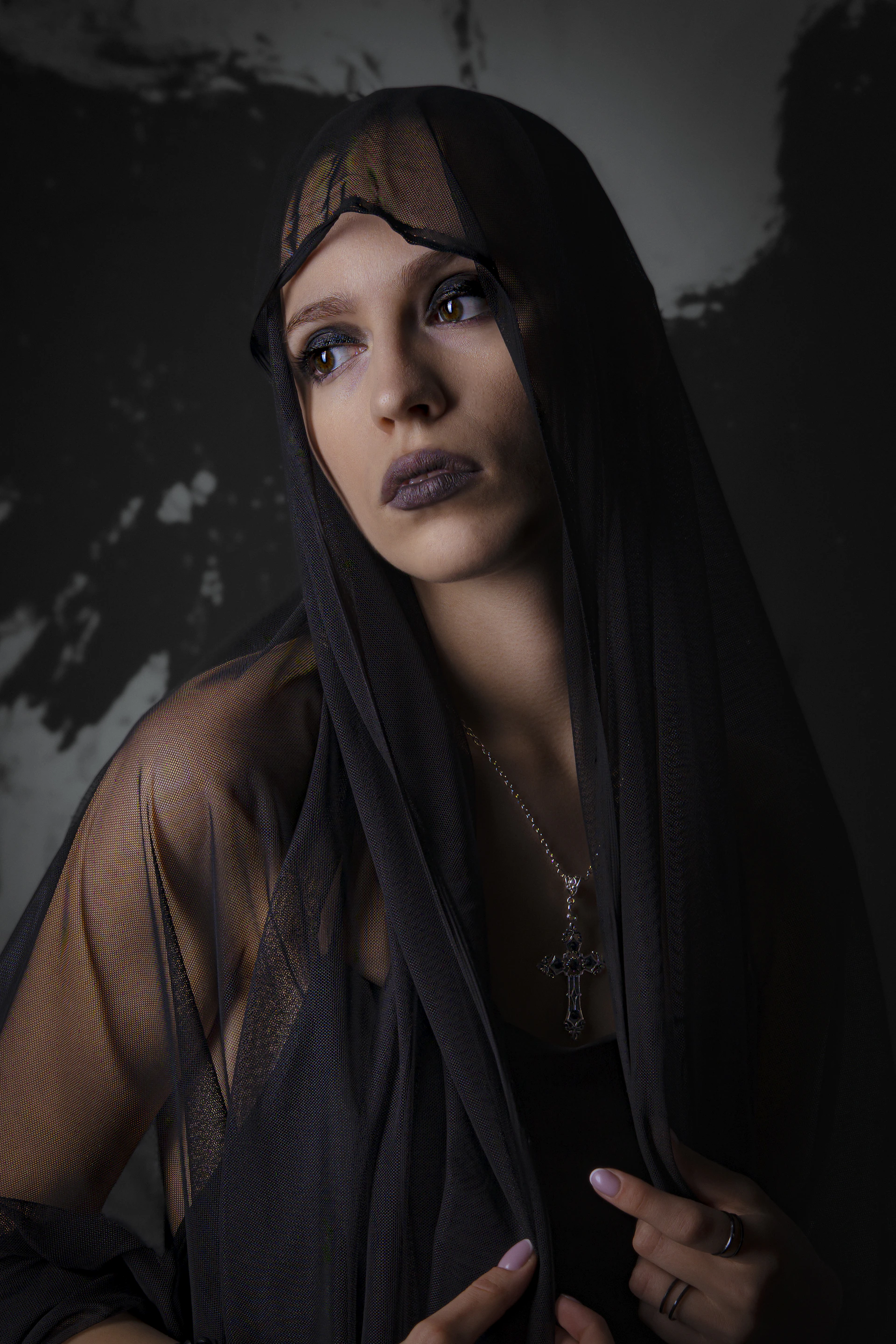 Woman in black veil with cross necklace
