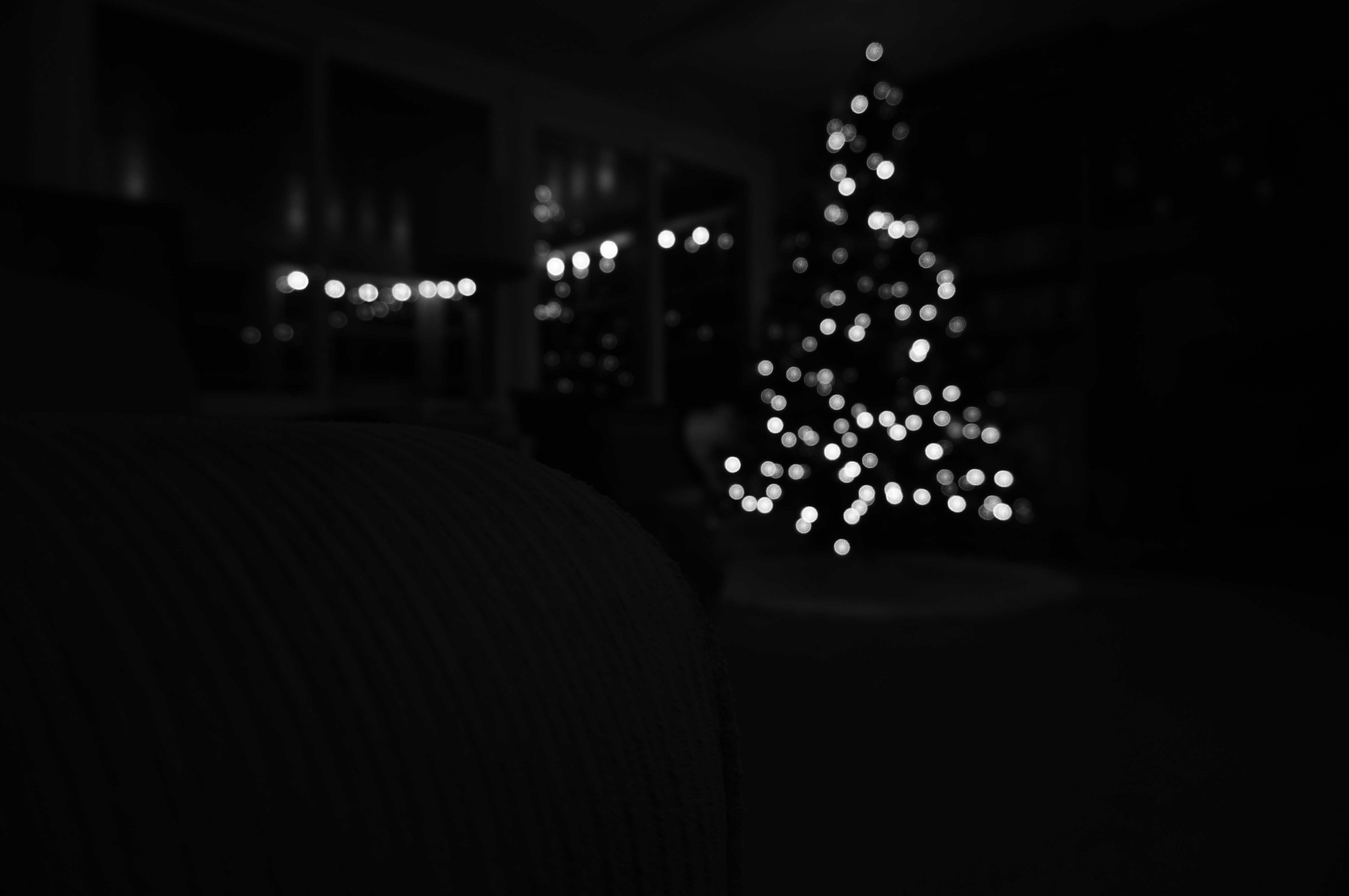 A blurred christmas tree with glowing lights at night.
