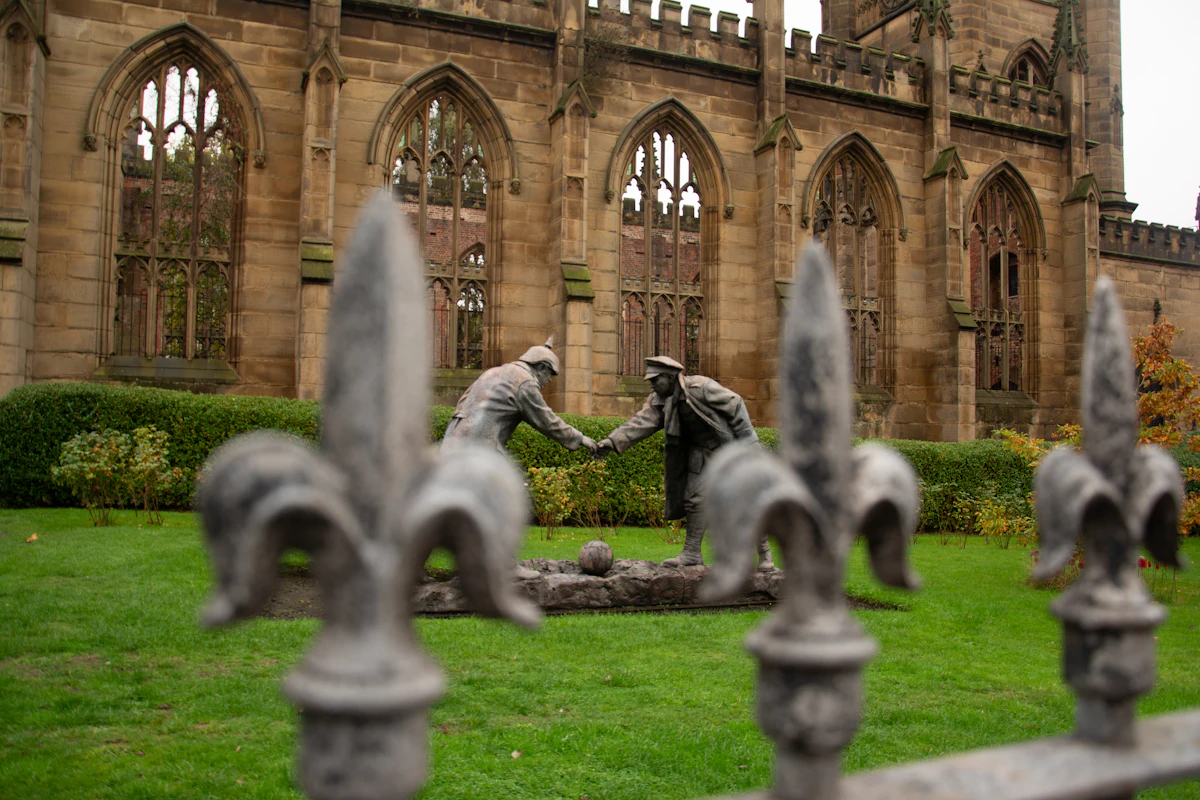 Dua patung berjabat tangan di depan bangunan reruntuhan (lambang damai)