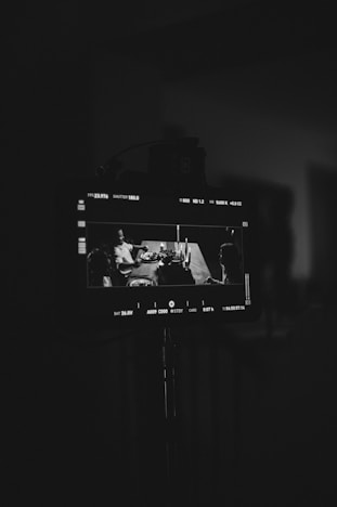 A monitor displays a scene with people at a table