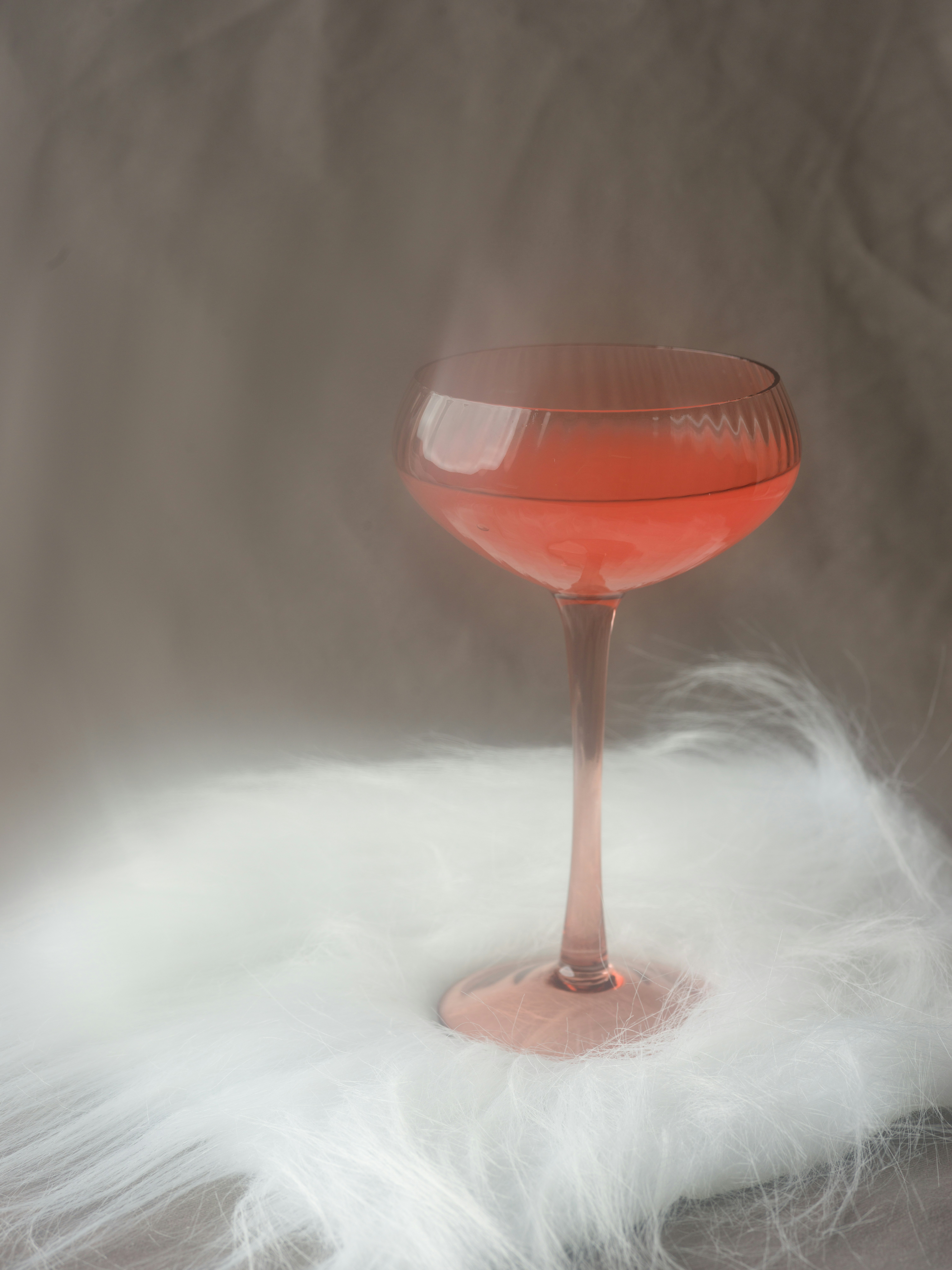 모피에 줄기가 있는 잔에 담긴 핑크색 칵테일