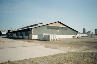 A large industrial warehouse building under a clear sky.