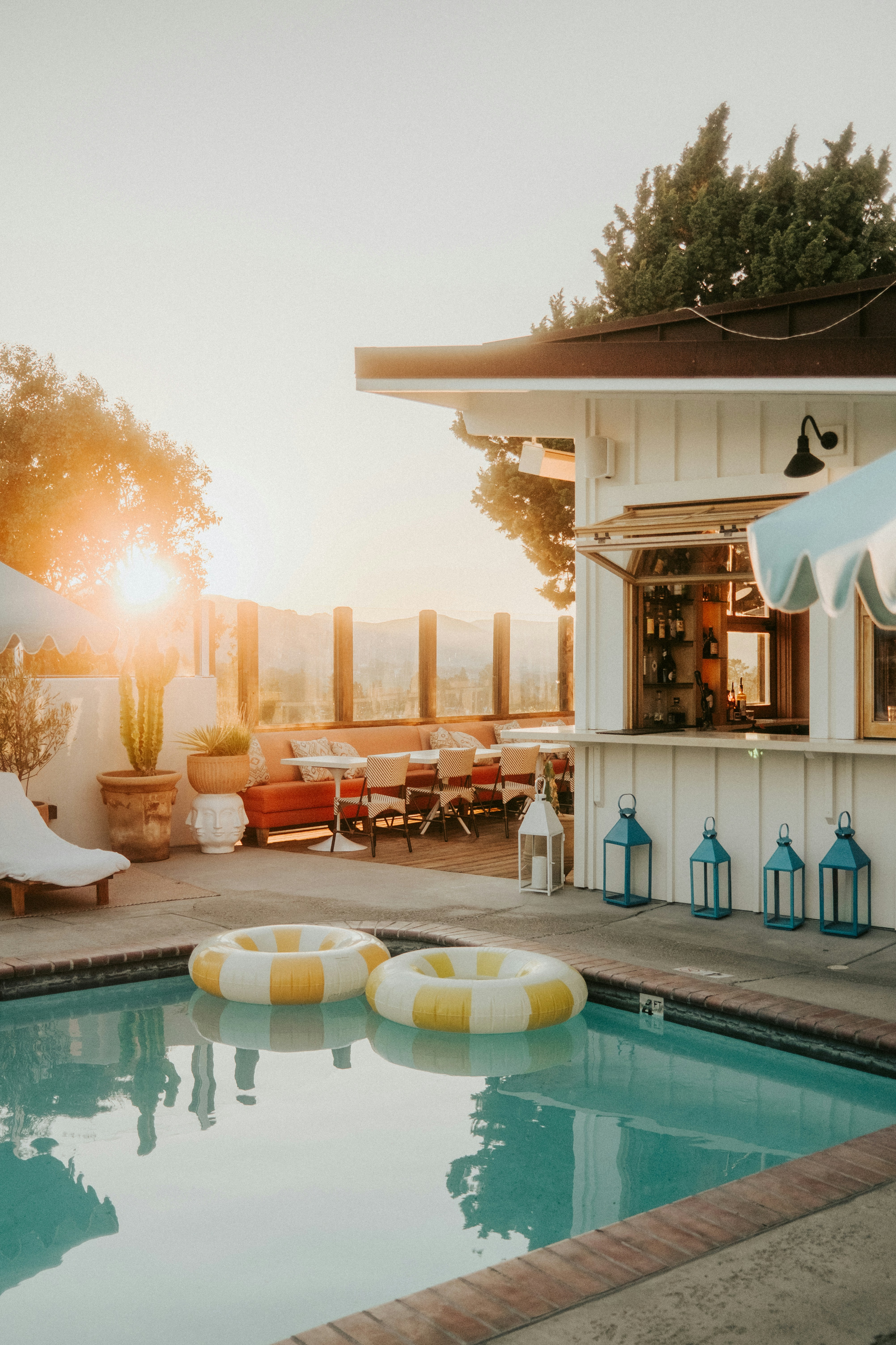 Poolside bar with inflatable rings at sunset