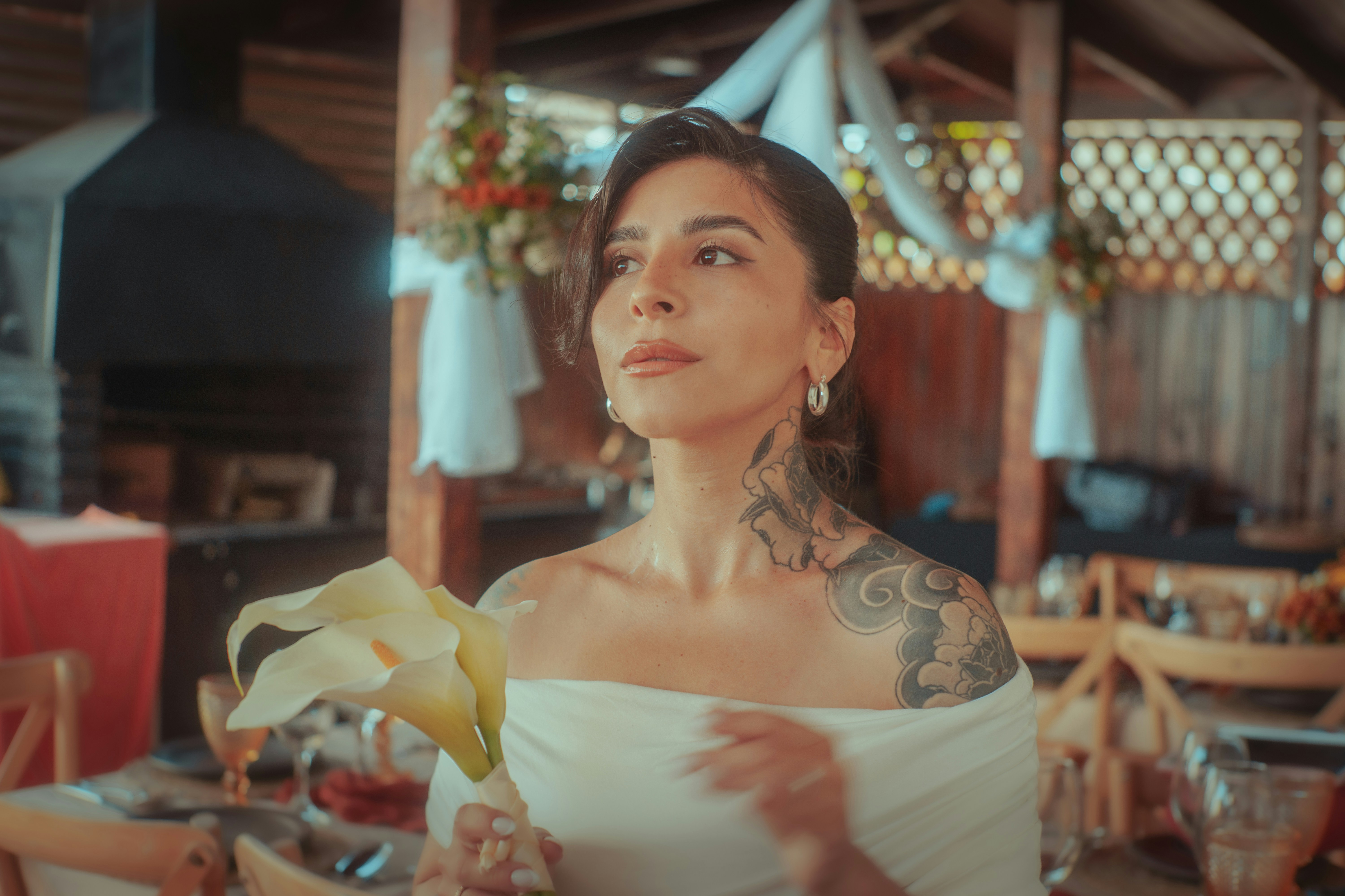 Bride holding a calla lily at an outdoor wedding.