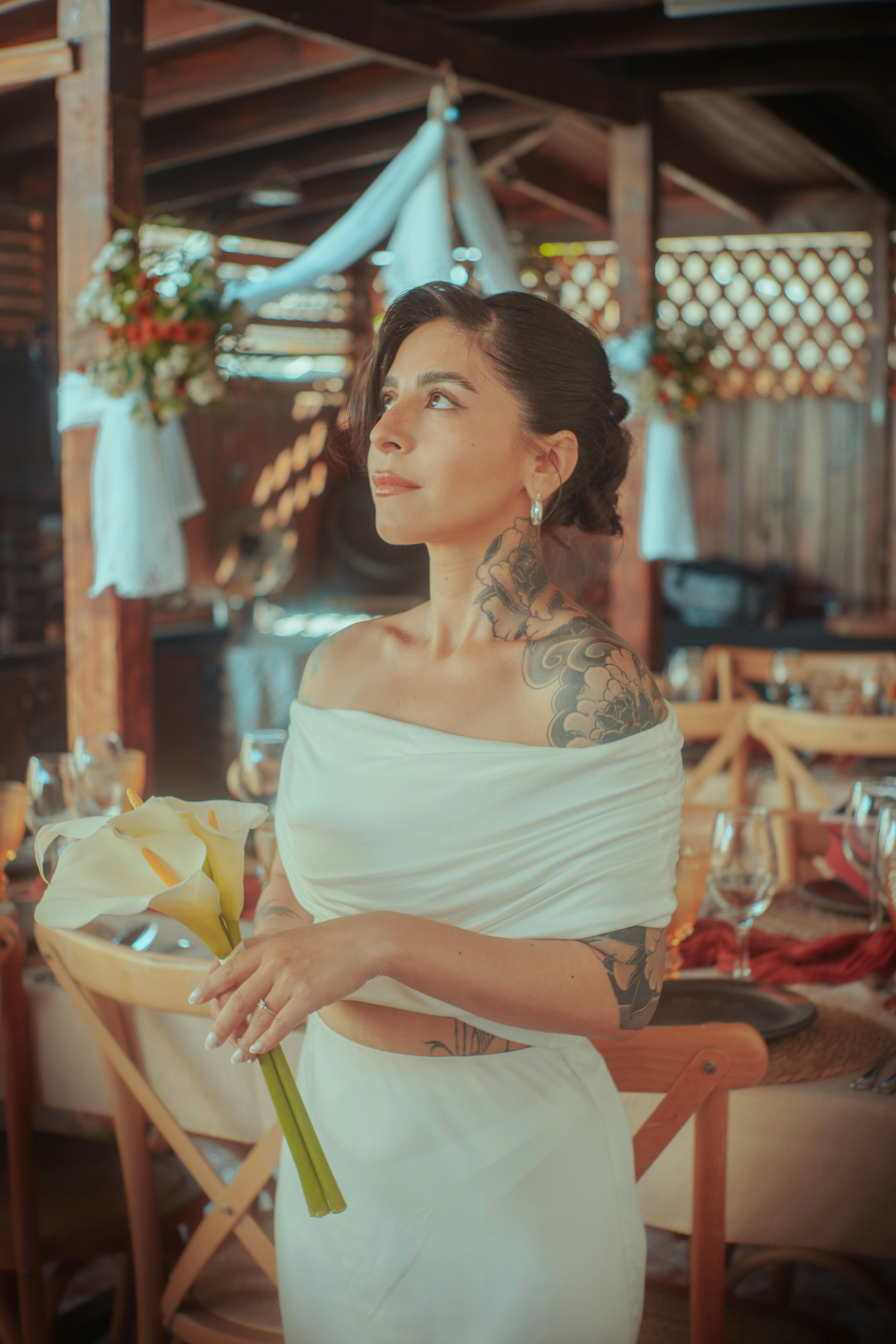 Sposa in abito bianco che tiene calle al ricevimento di nozze