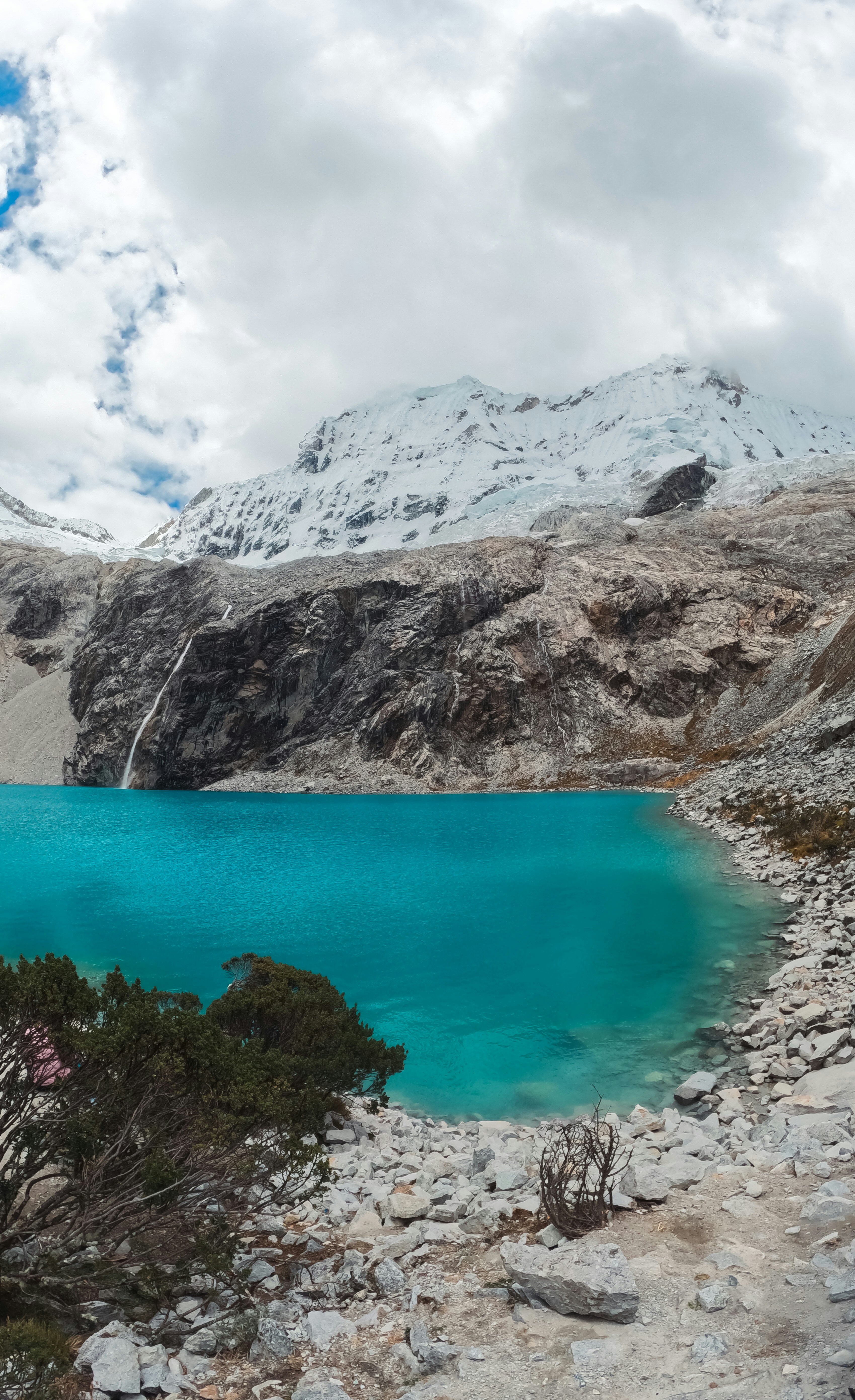 Turquoise mountain lake with snow-capped peaks above.