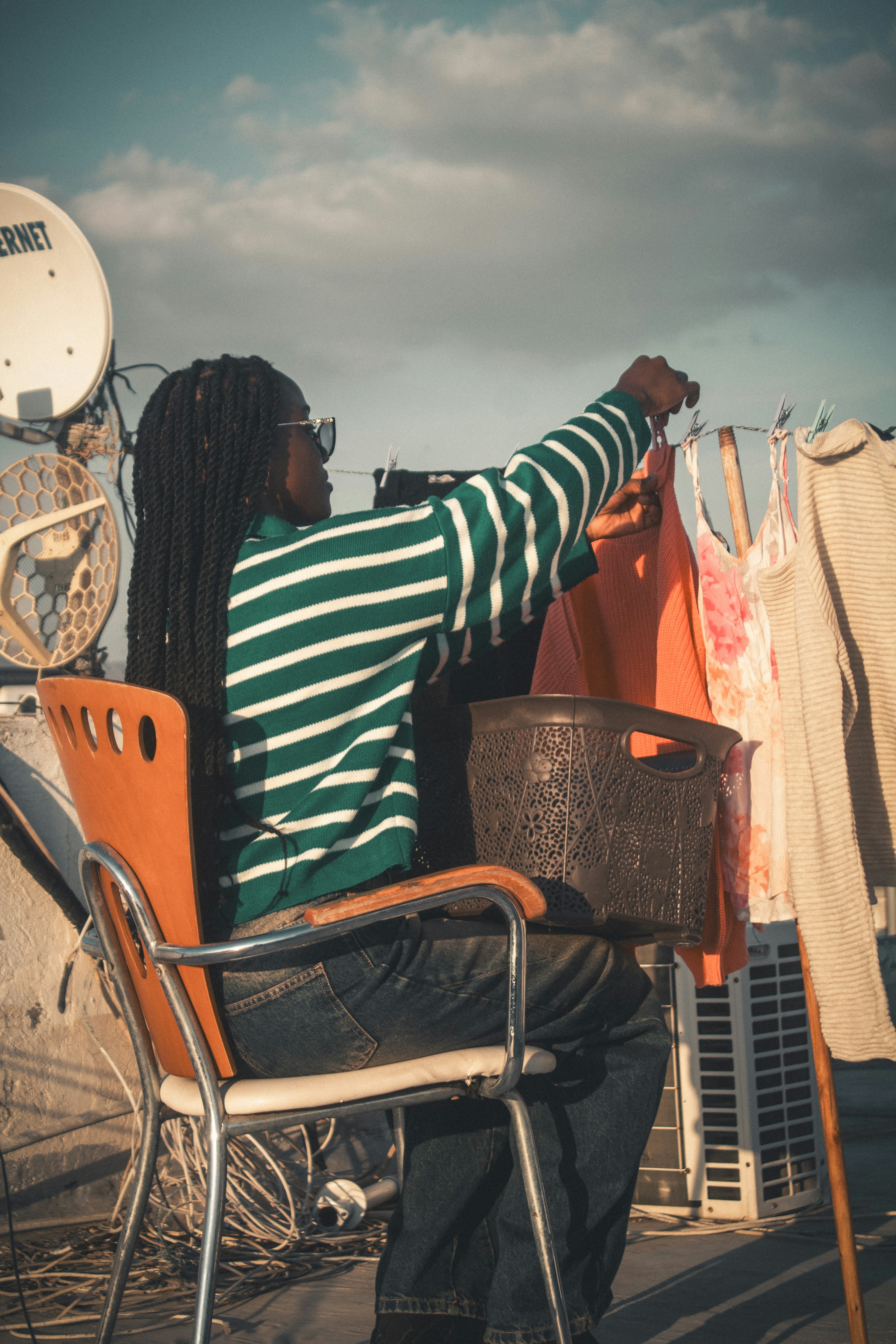 Woman hanging laundry on a clothesline outdoors.
