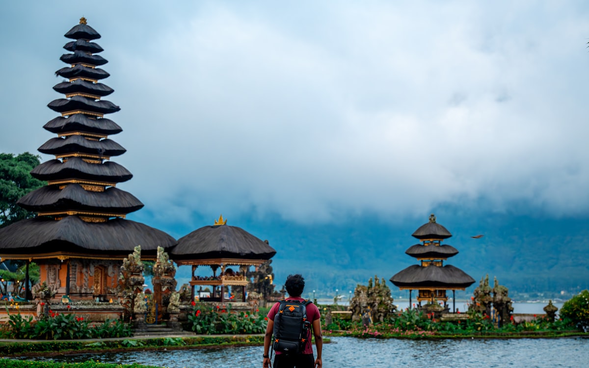 Man looking at ancient temple by the water