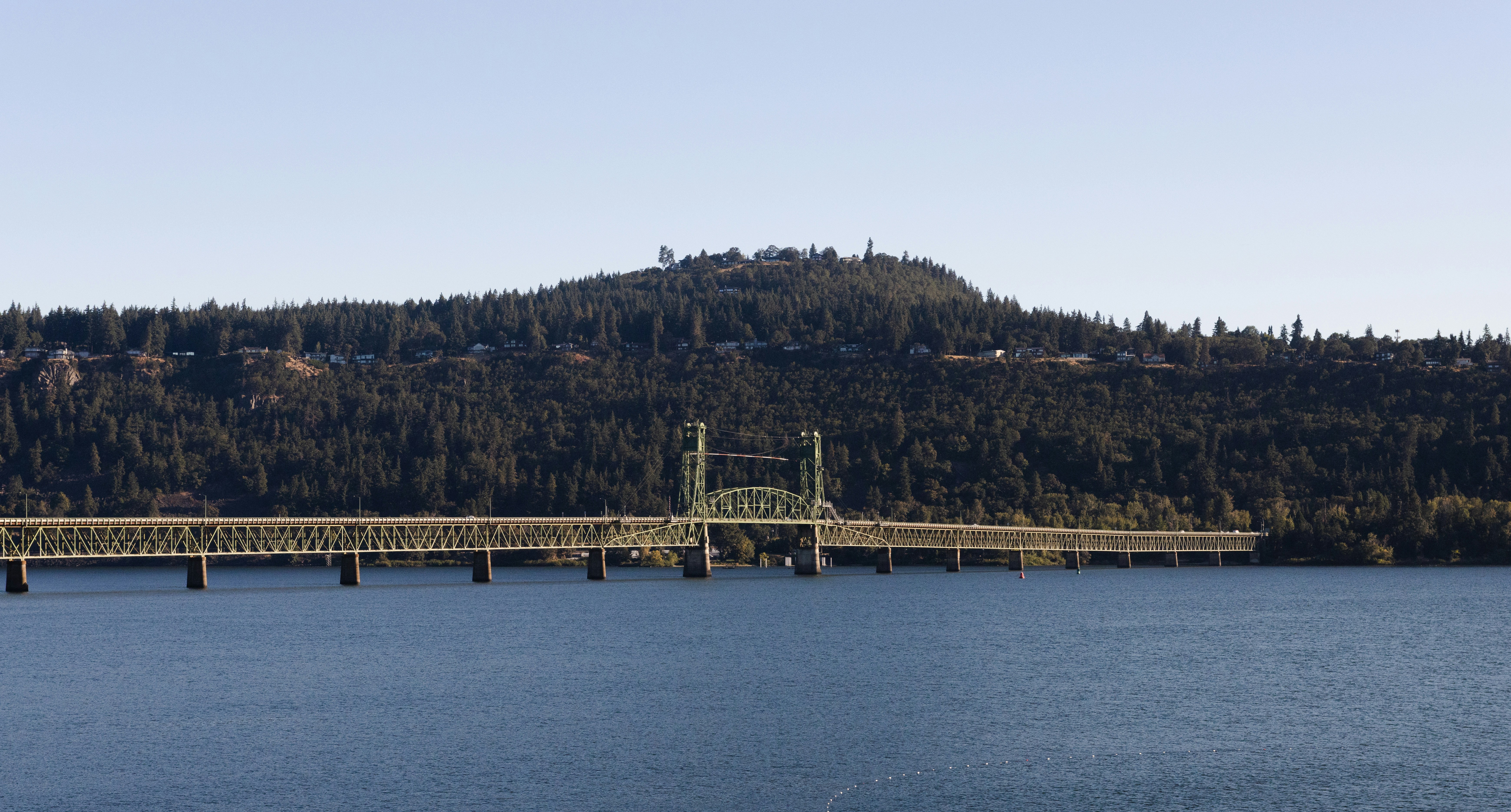 Green bridge over a wide blue river