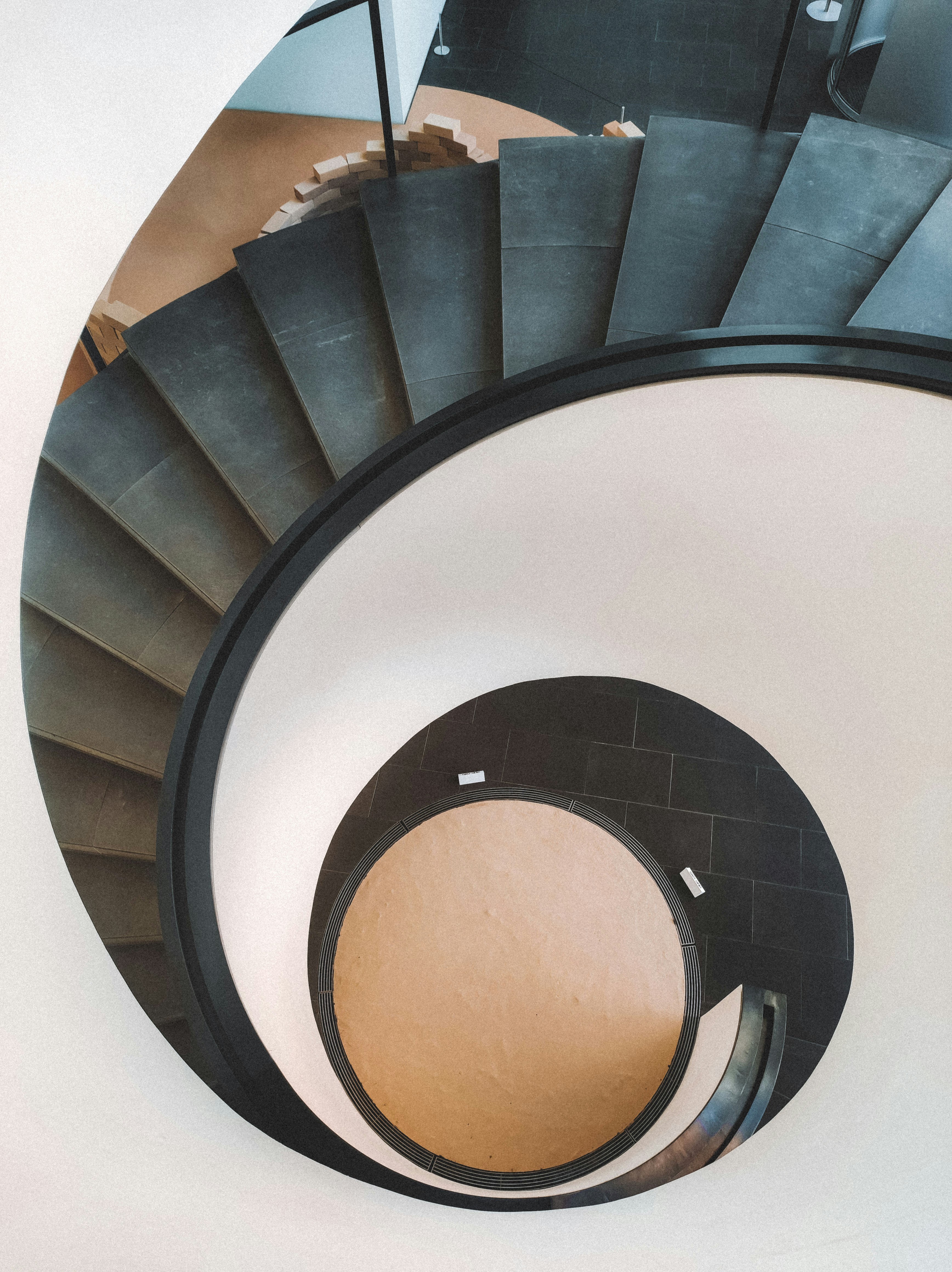 A modern spiral staircase with dark steps