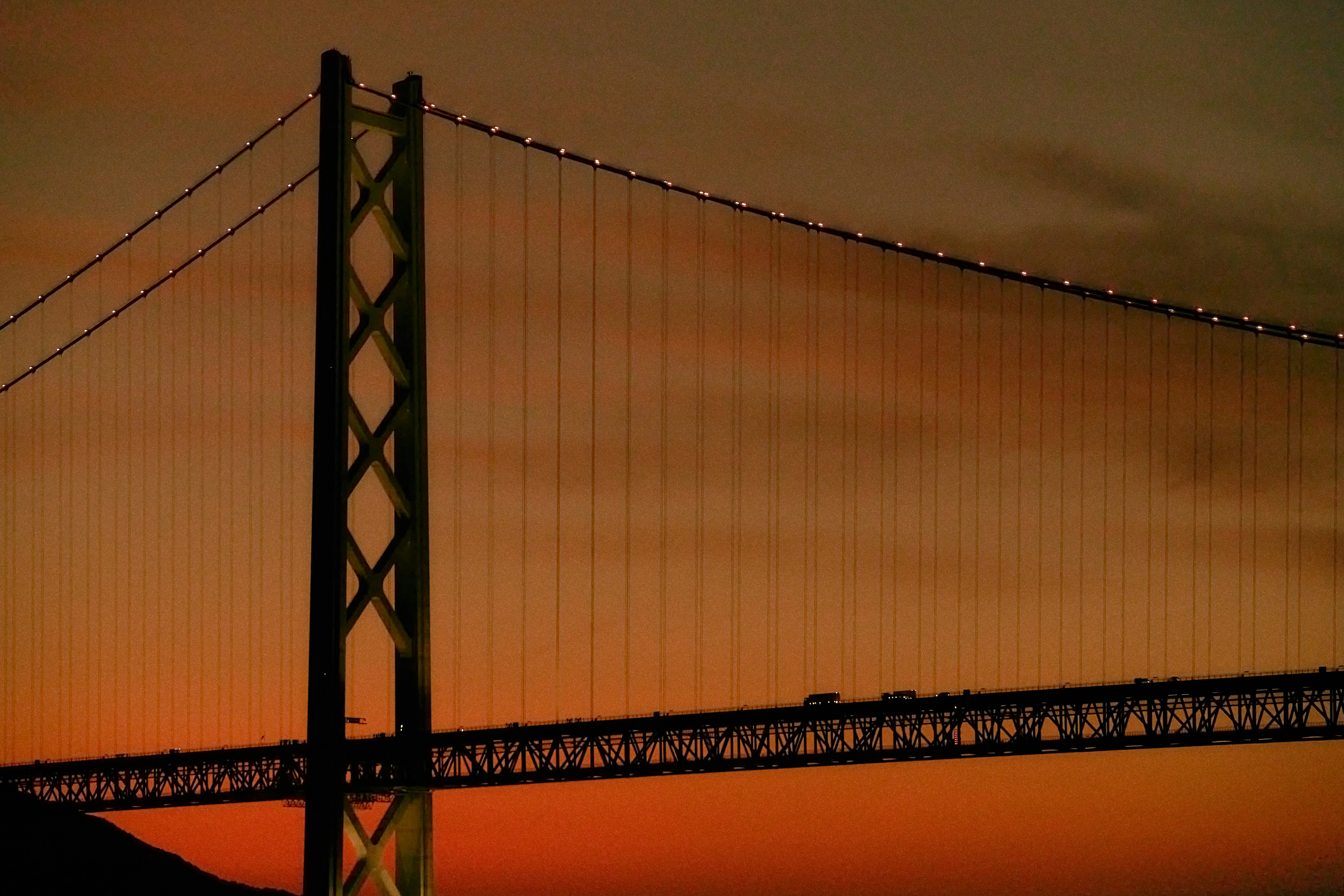 Suspension bridge with lights at dusk.