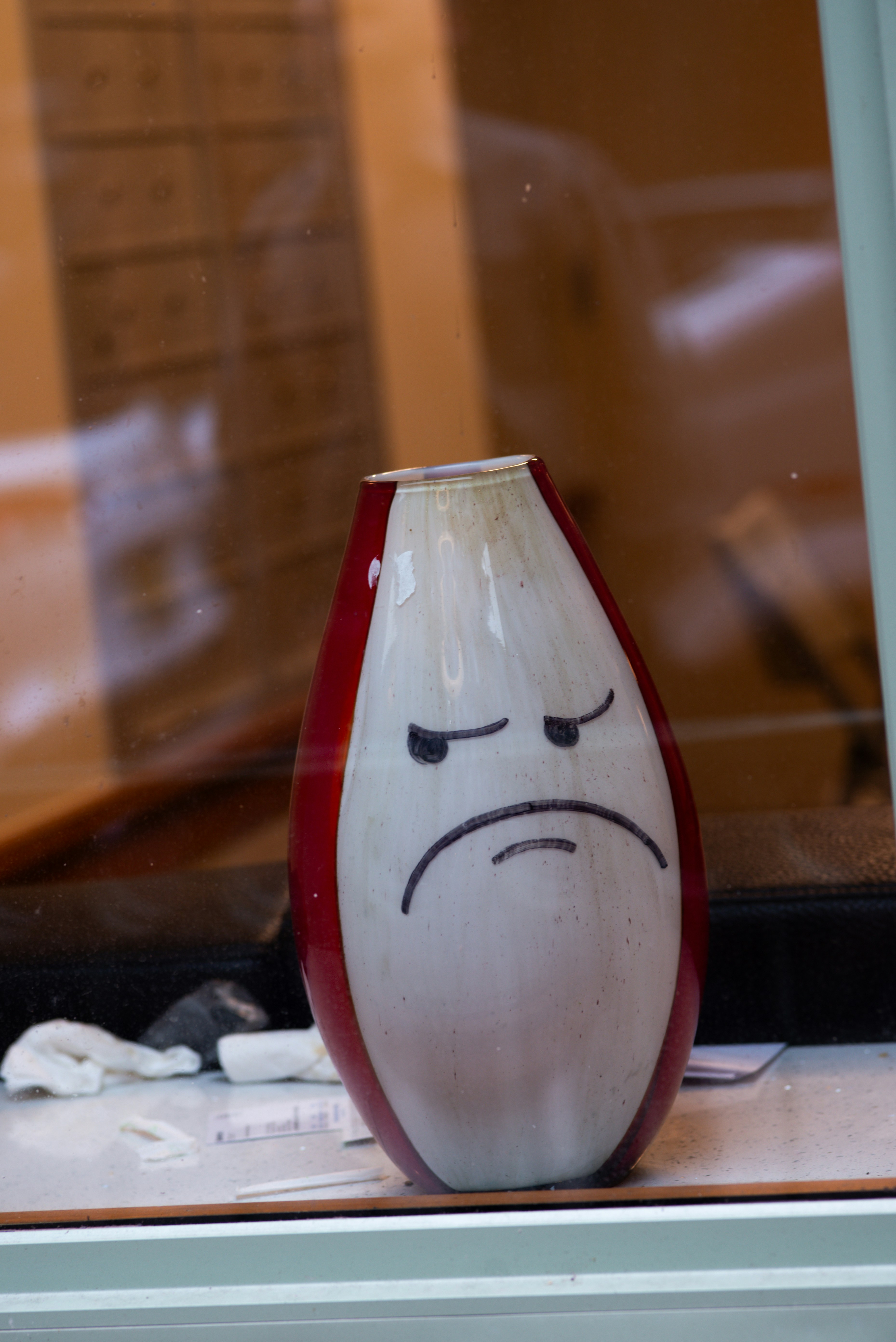 A vase with a grumpy face drawn on it.
