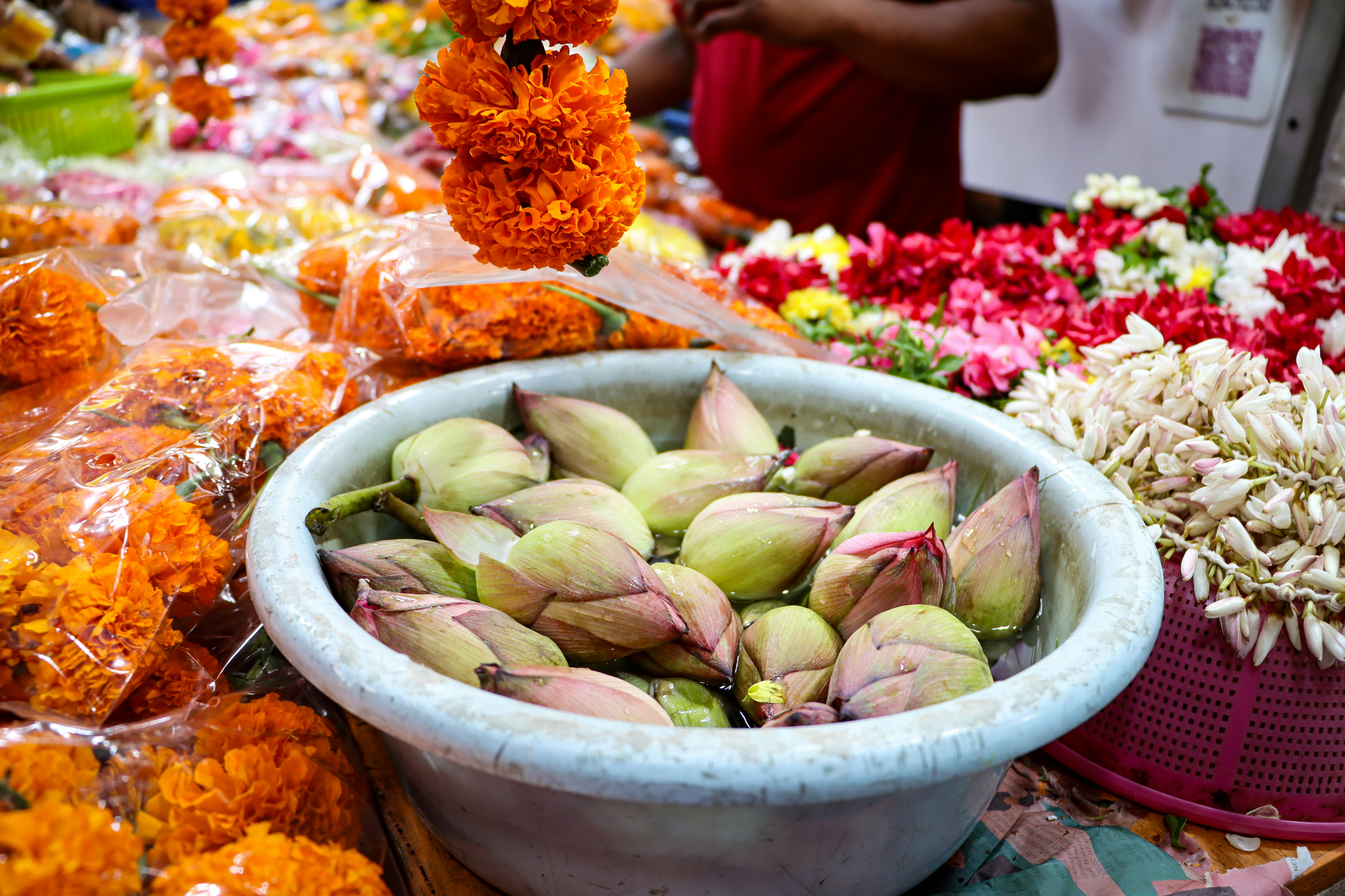 Schale mit Lotusknospen mit Ringelblumengirlanden
