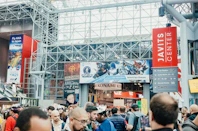 Crowd entering javits center with large advertisements displayed