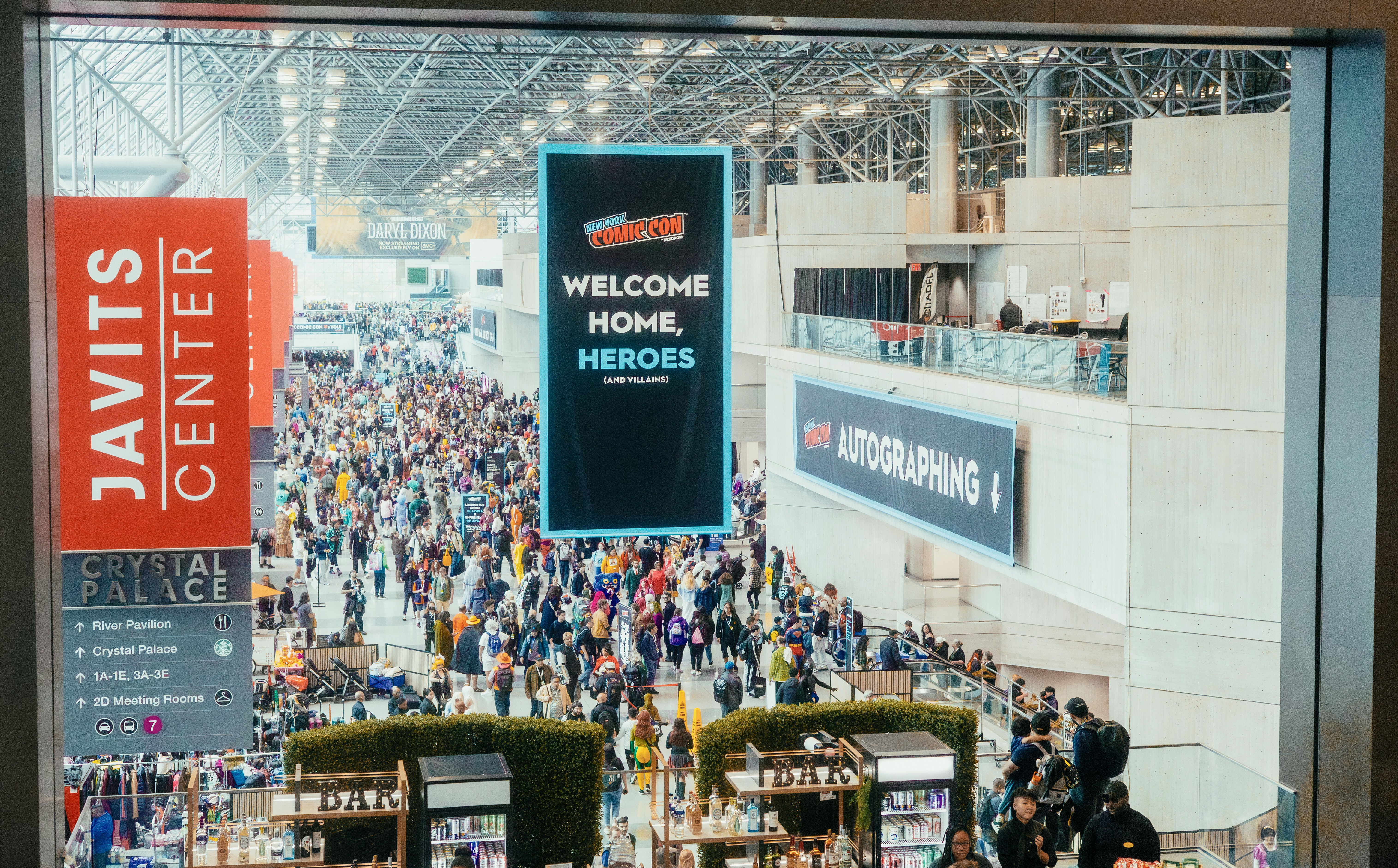Crowded javits center with "welcome home, heroes" banner.