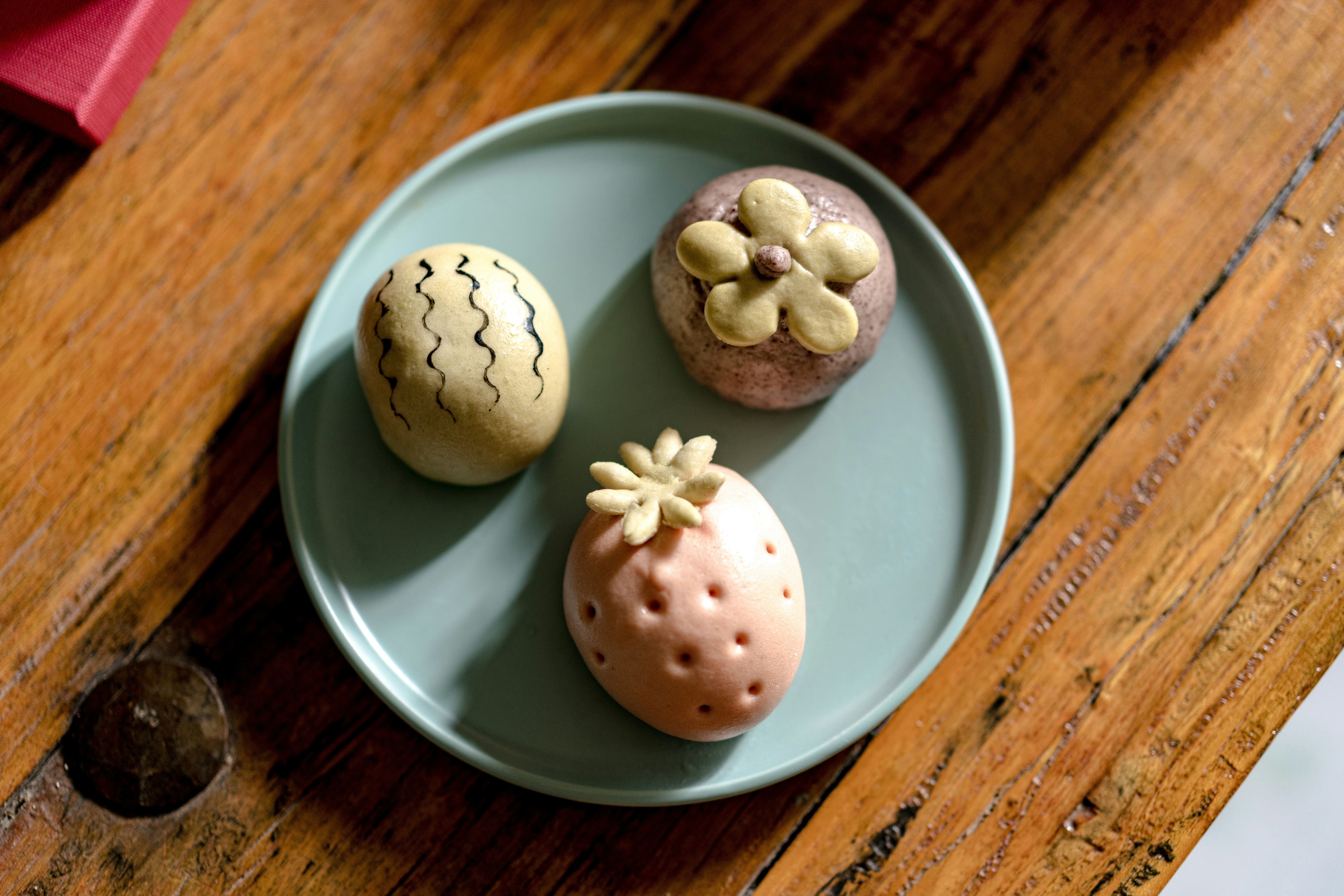 Three decorative pastries on a blue plate.