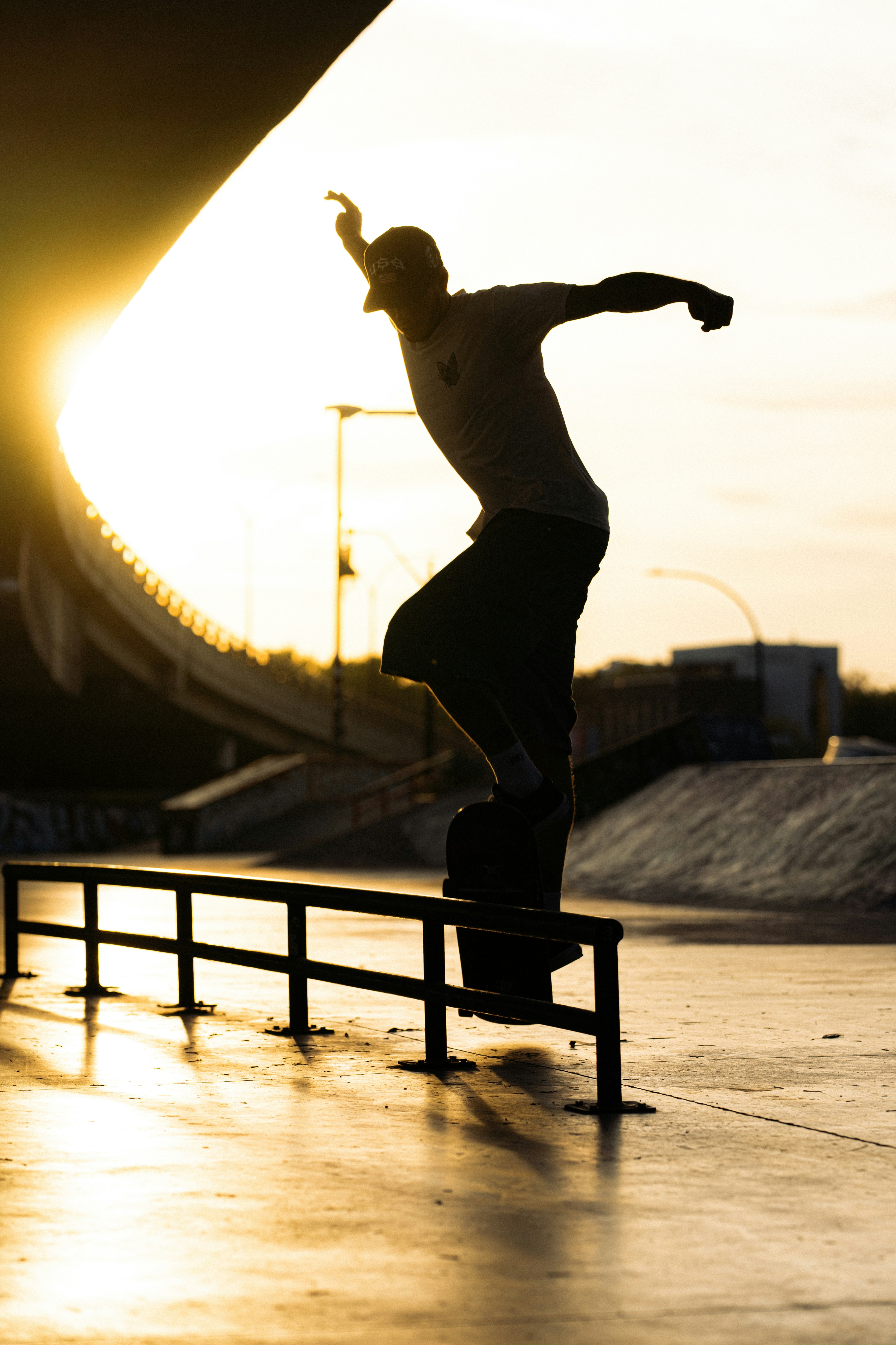 Un skateur grince sur un rail au coucher du soleil.
