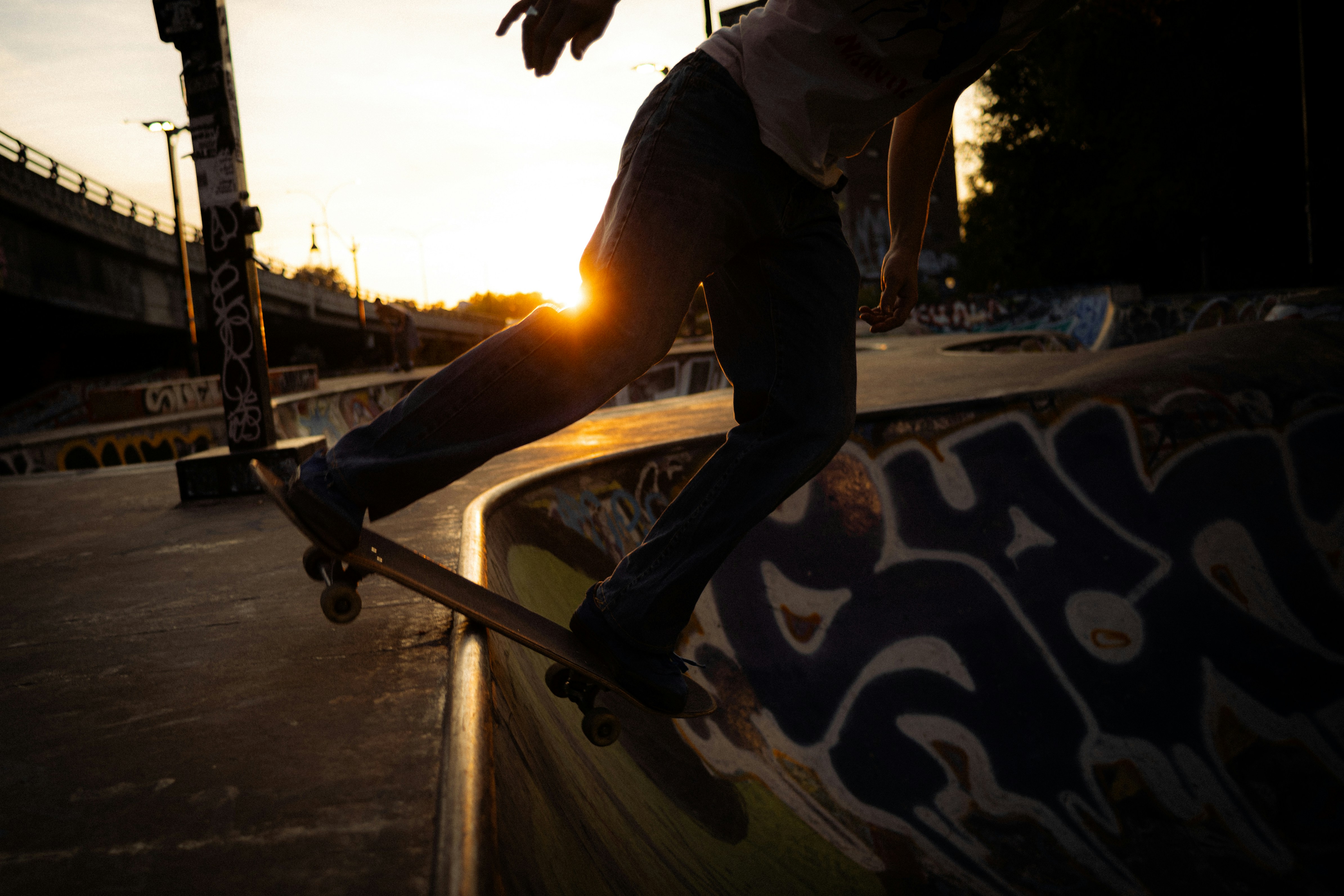 Un skateur monte sur une rampe au coucher du soleil