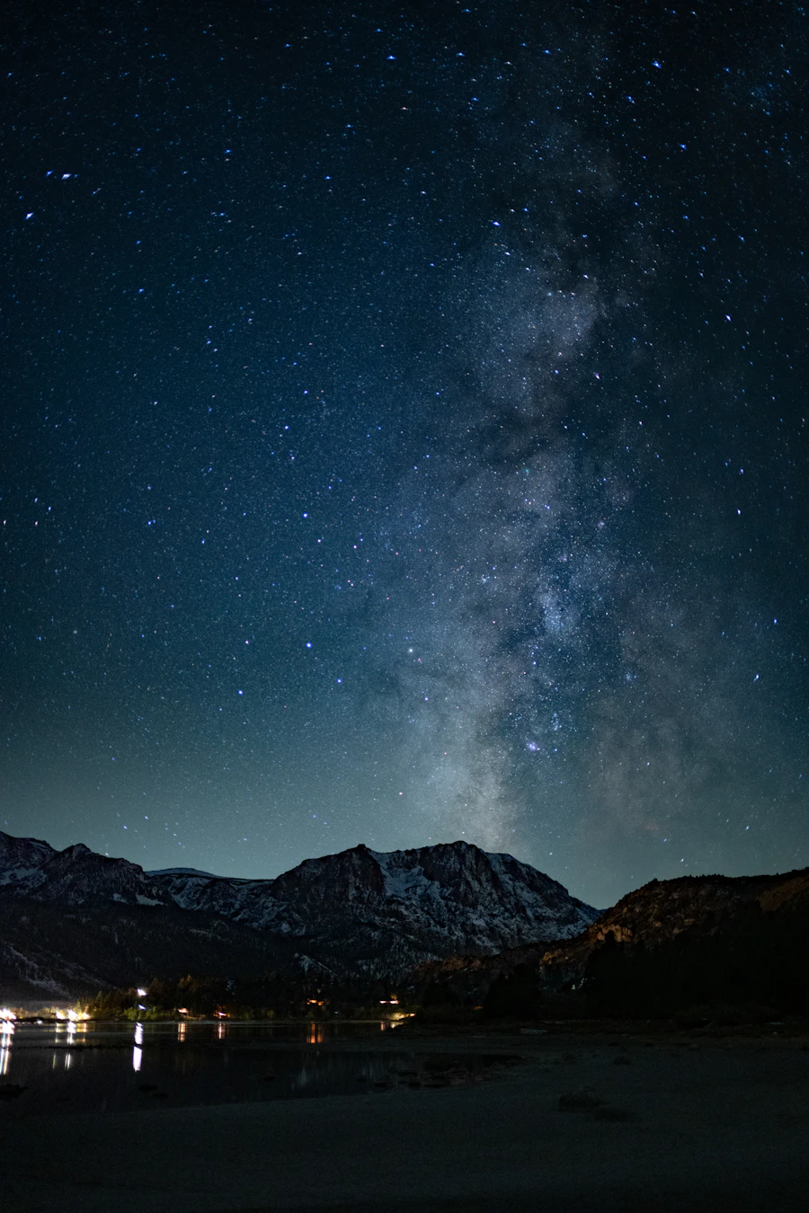 The Milky Way stretching across a night sky above snow-covered mountain peaks