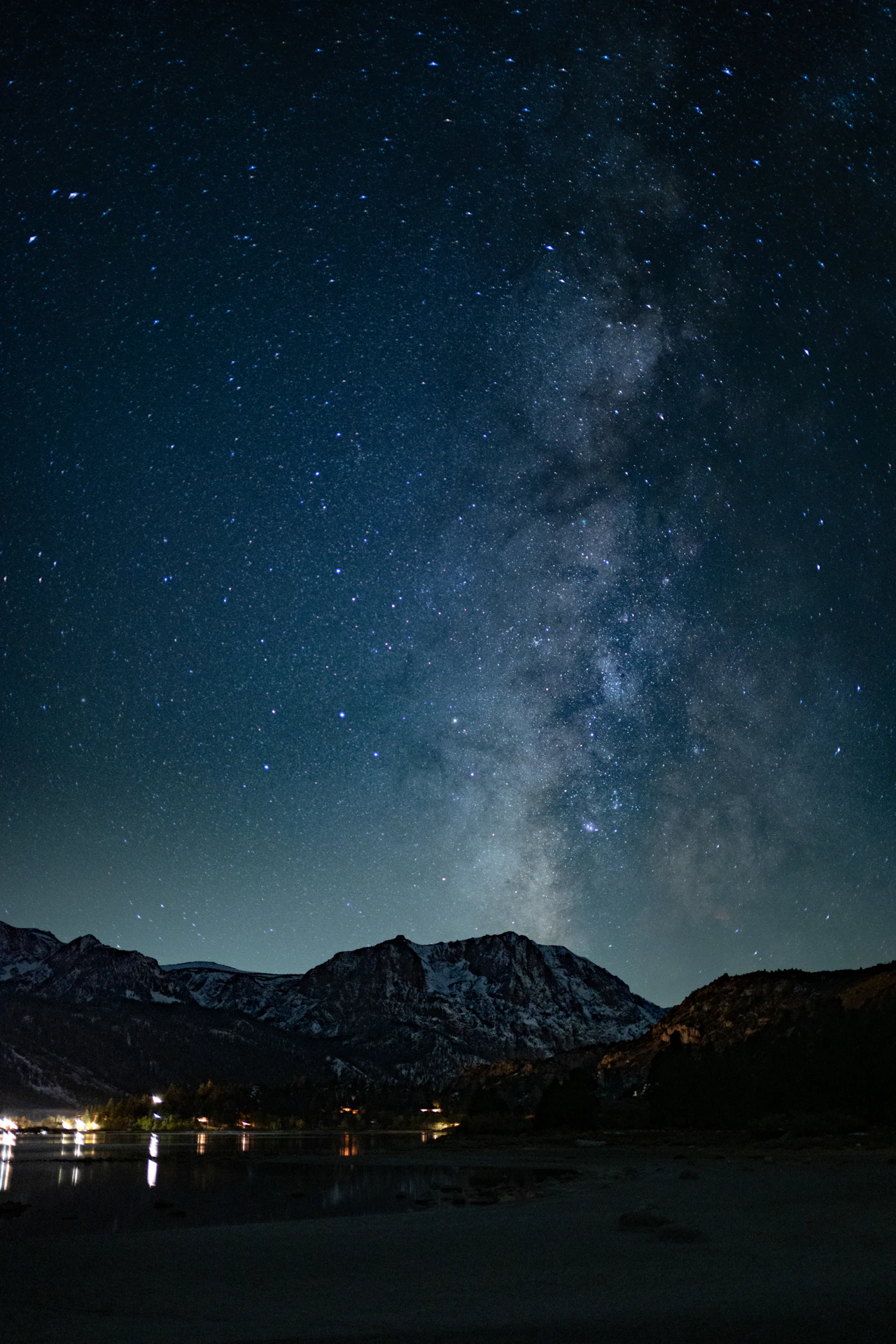 The Milky Way stretching across a night sky above snow-covered mountain peaks