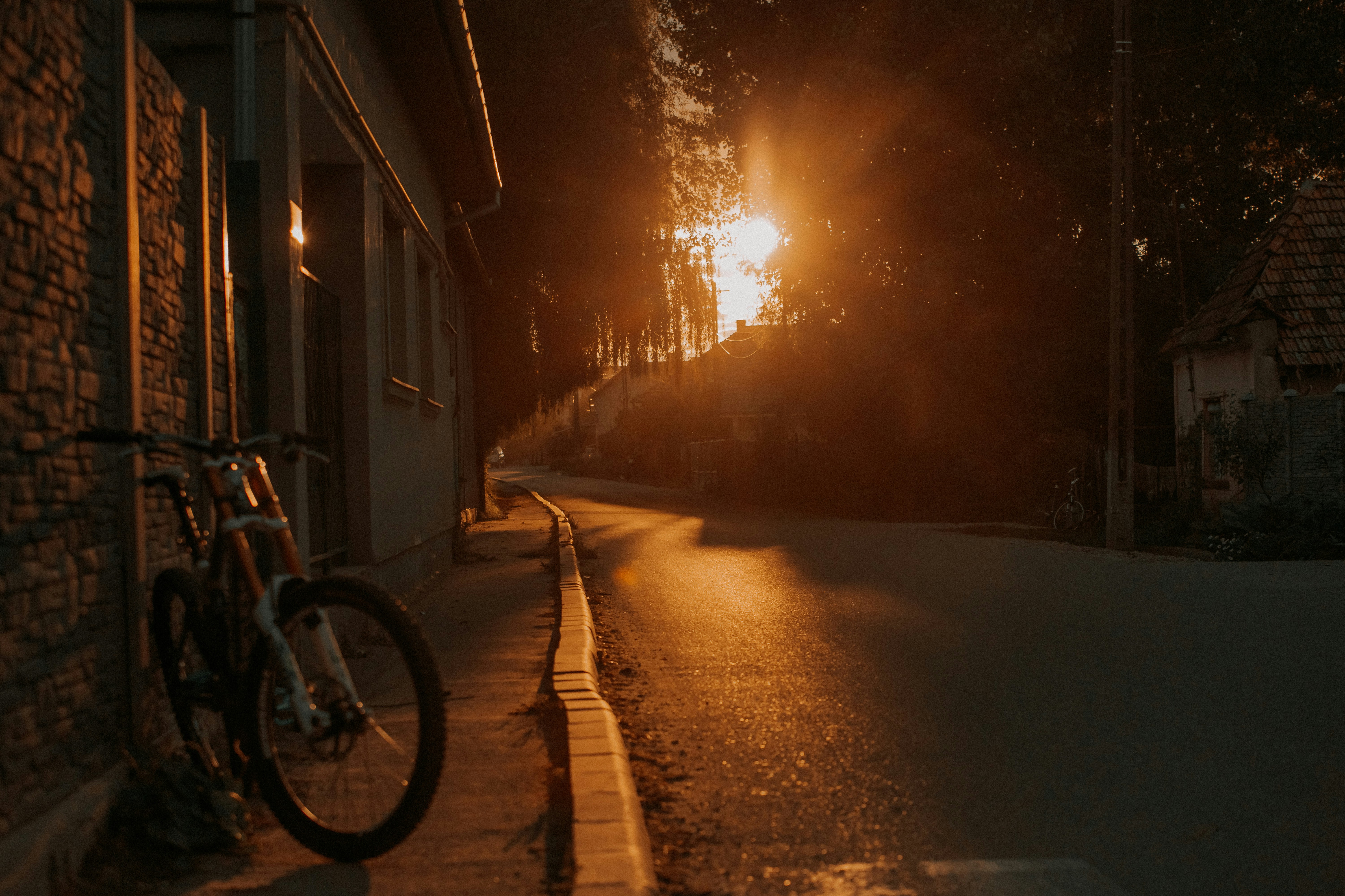 Bicycle parked on a street at sunset