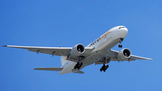 A commercial airplane flying in a clear blue sky.