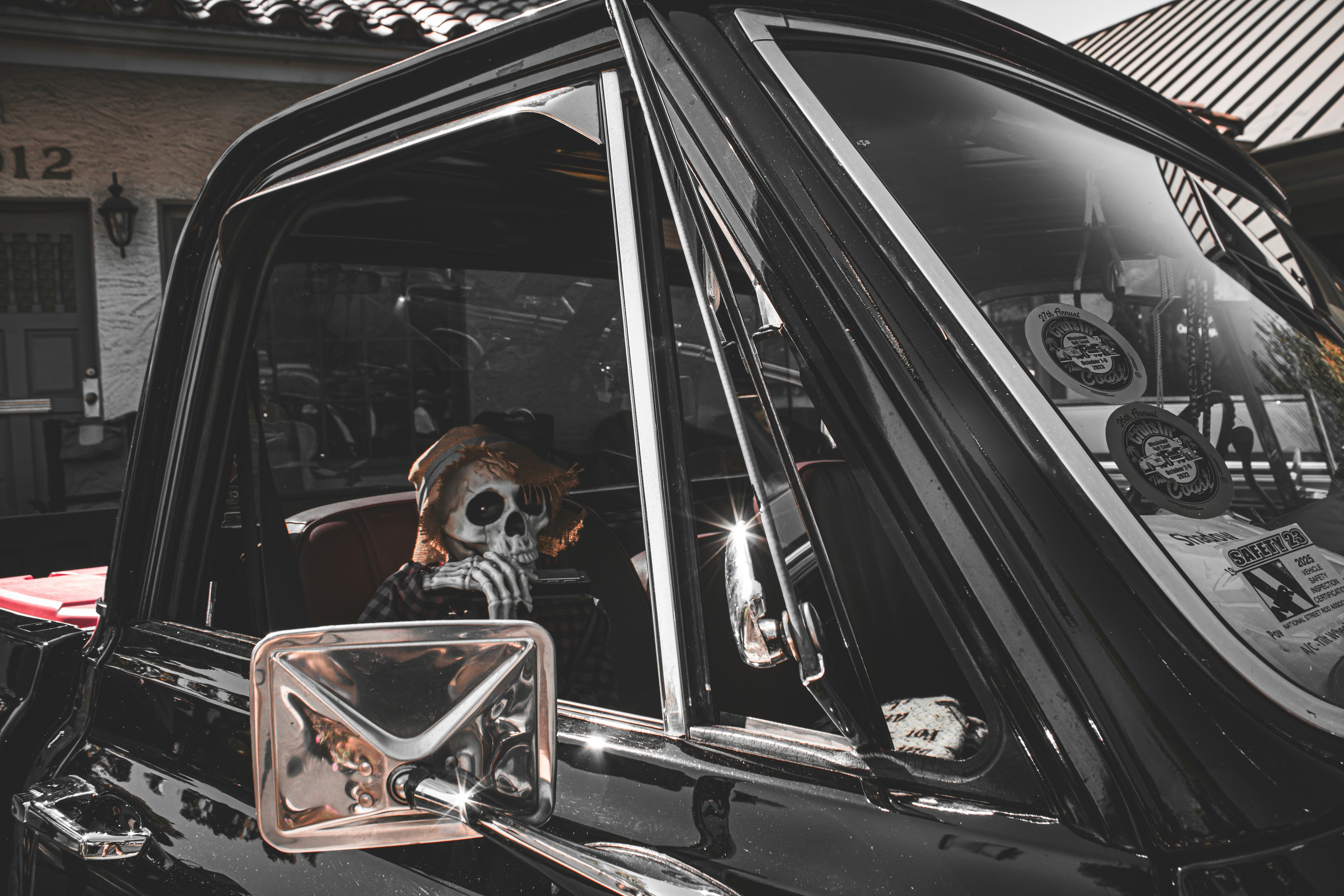 Skeleton driver in a vintage black pickup truck