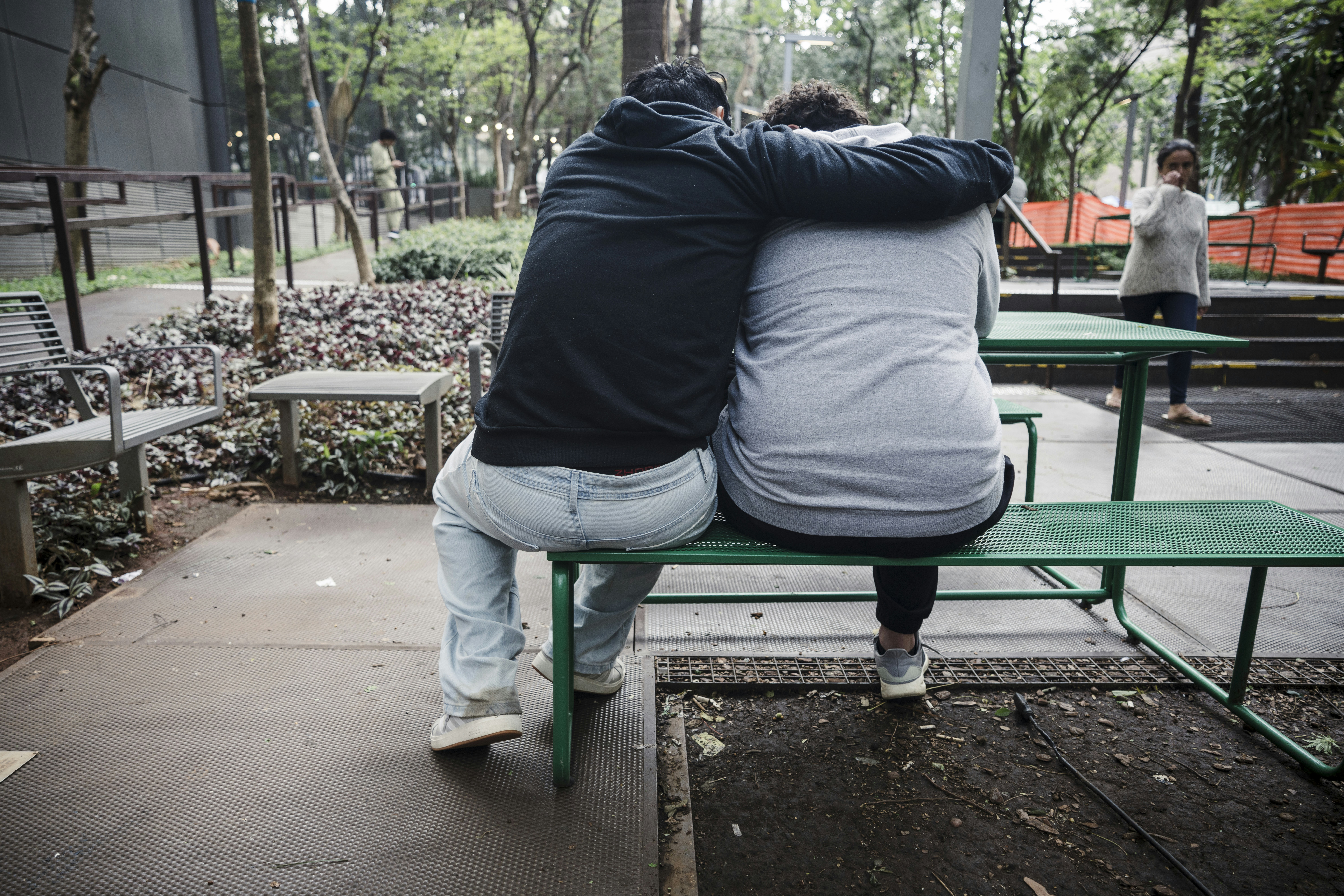 Two people sitting together on a park bench.