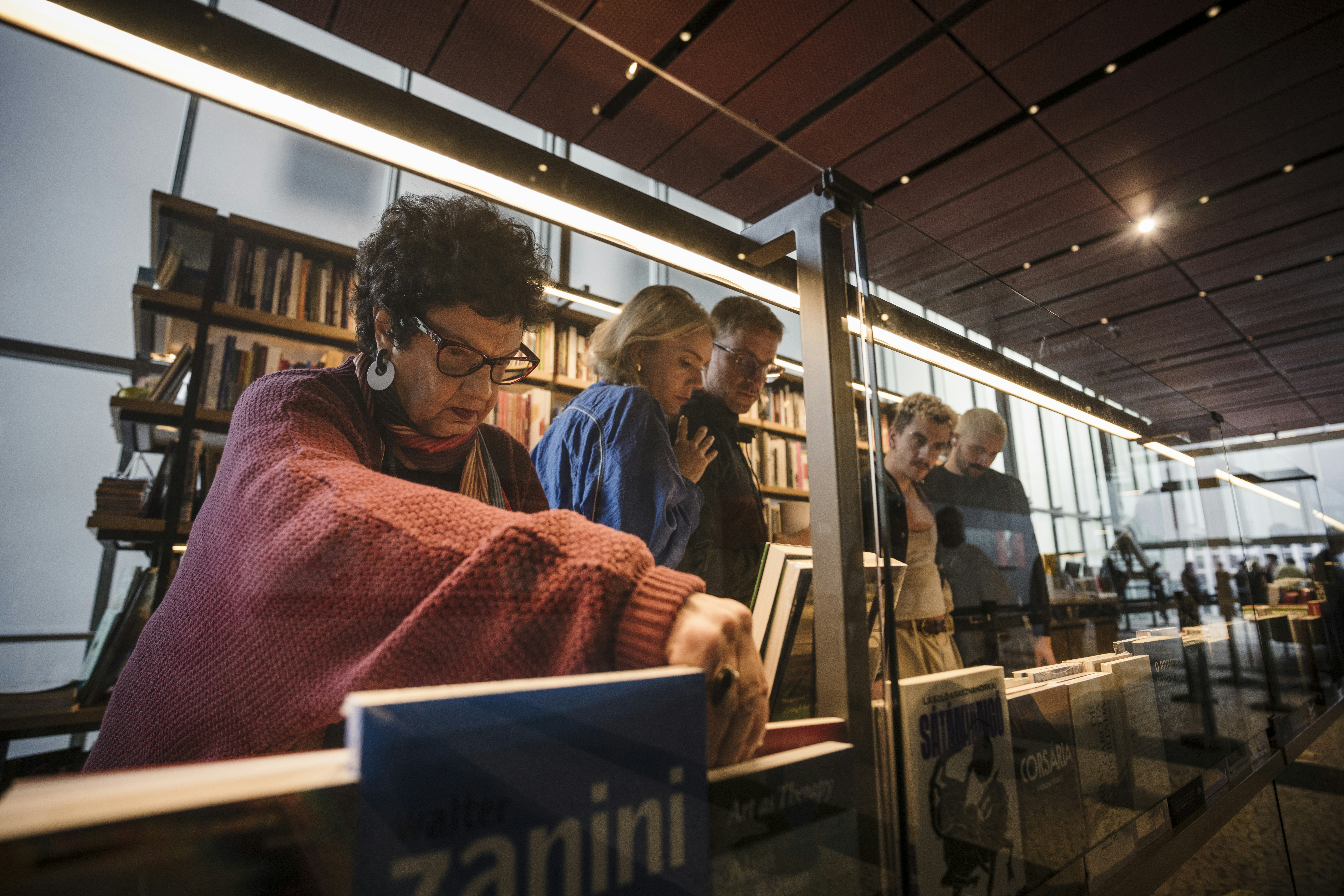 People browsing books in a library or bookstore.
