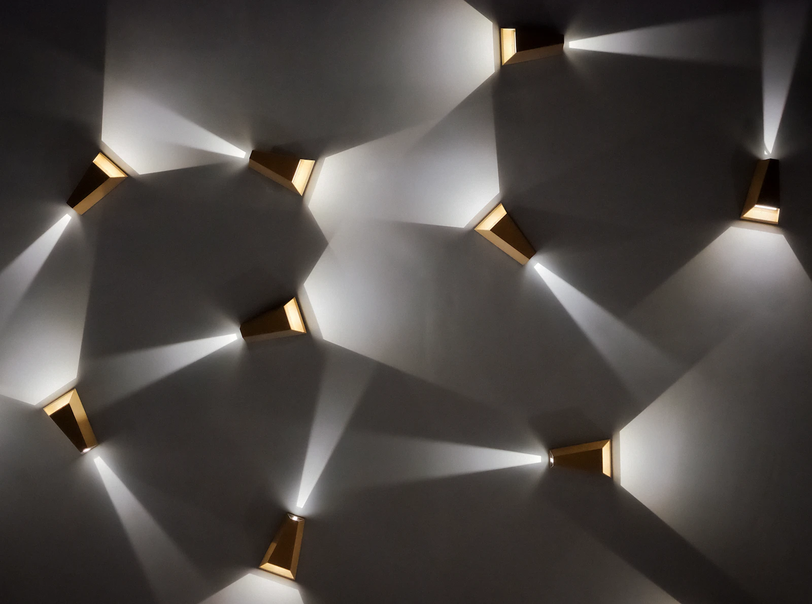 Modern wall sconces casting warm light patterns on a wall