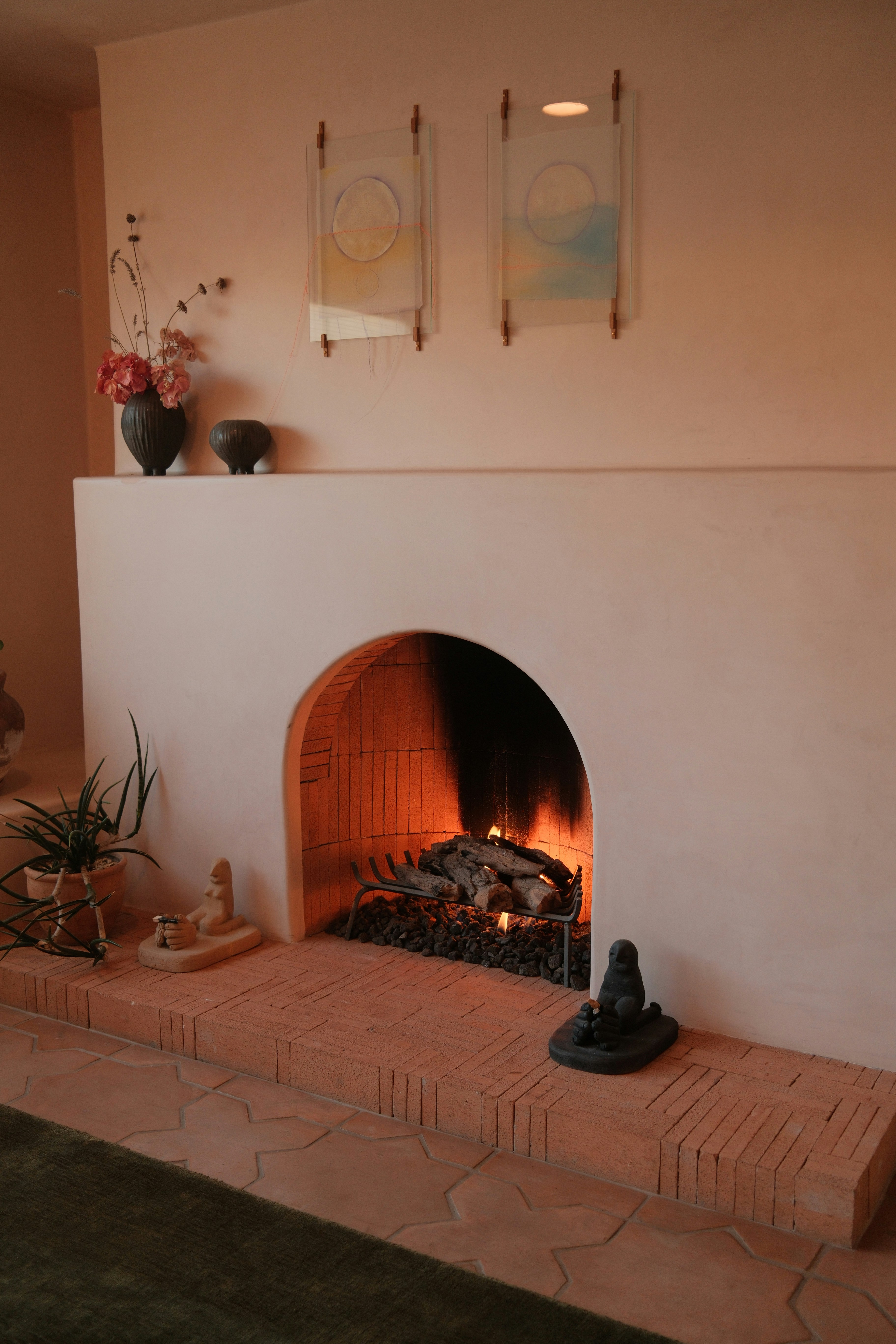 A cozy fireplace with burning logs and decorations.