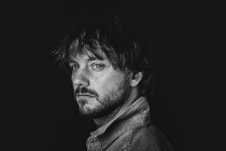 Man with beard looking over shoulder