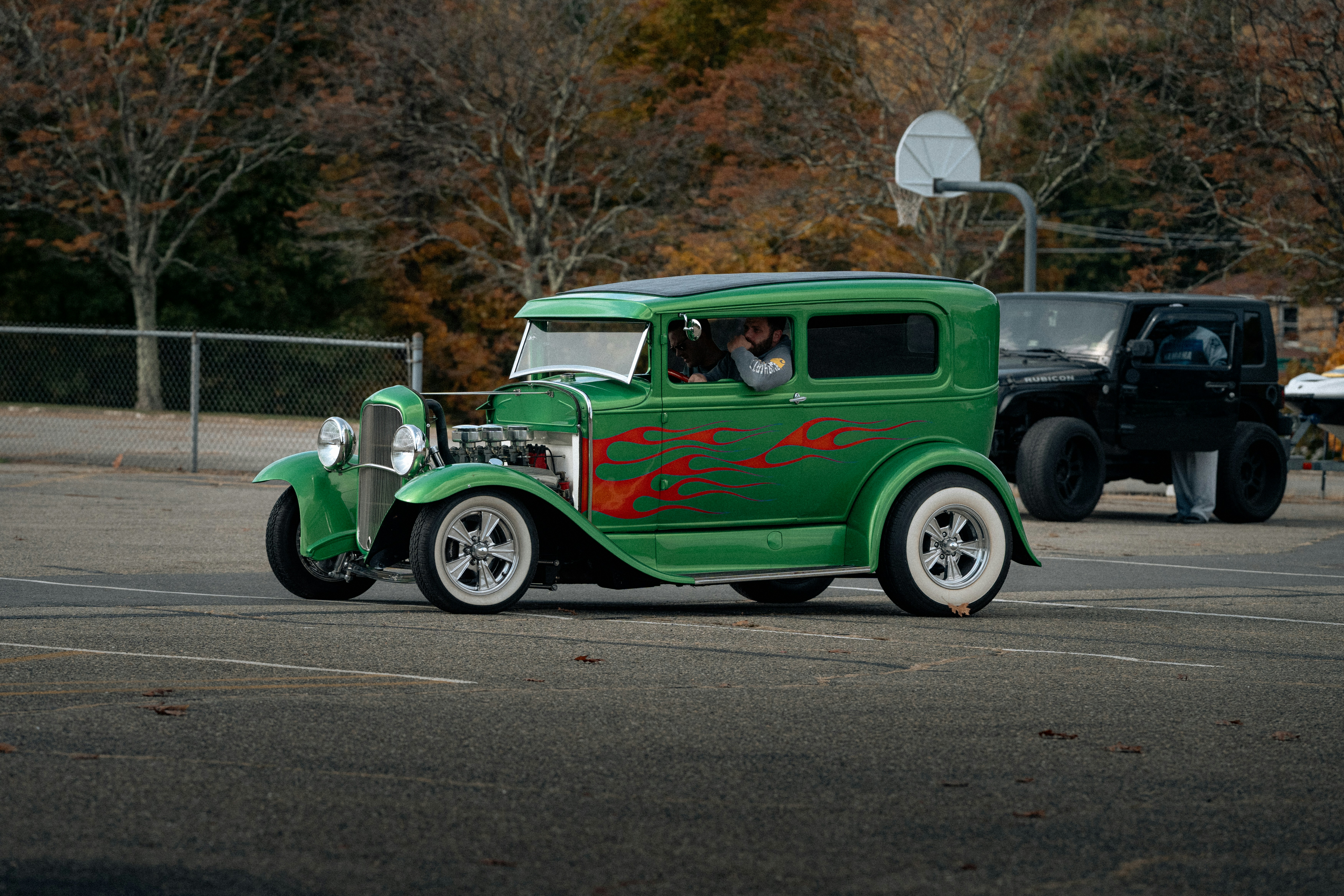 Green vintage car with flames on the side.