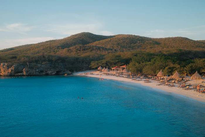 Secluded cove beach with turquoise water and green hills, similar to Colombier Beach
