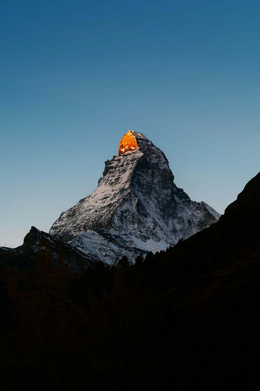 Matterhorn peak bathed in golden sunset light above Zermatt, Swiss Alps