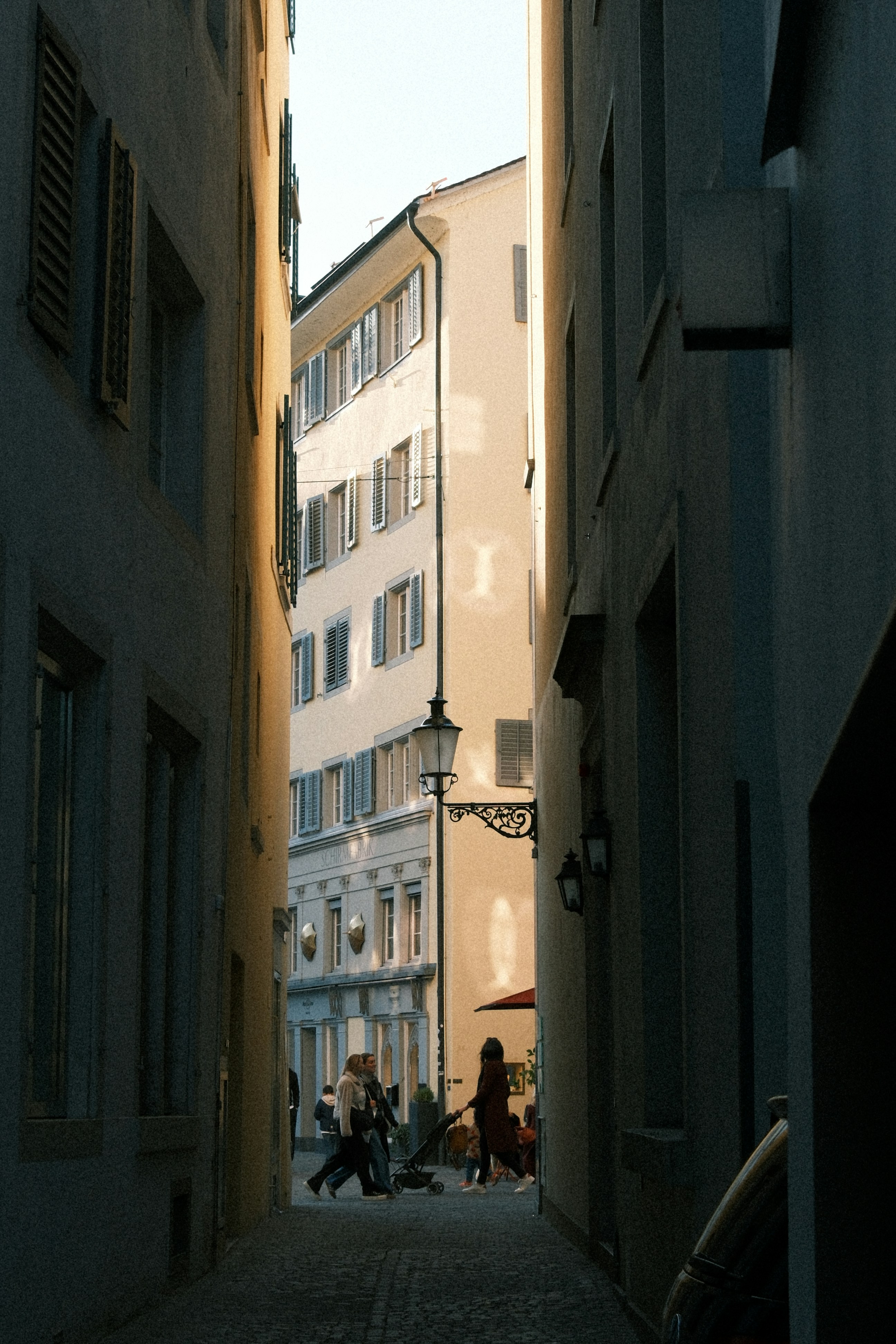People walking down a narrow european street.