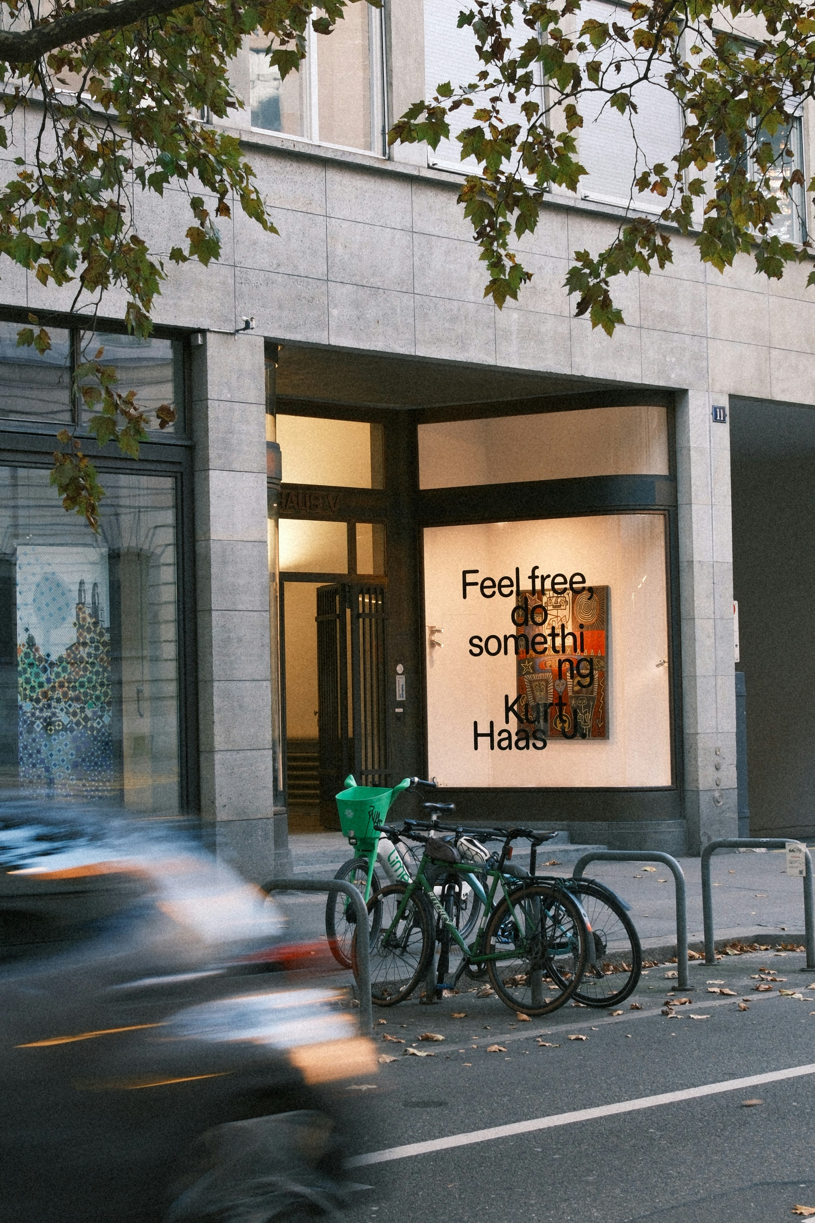 Bicycles parked outside a building with a window display.